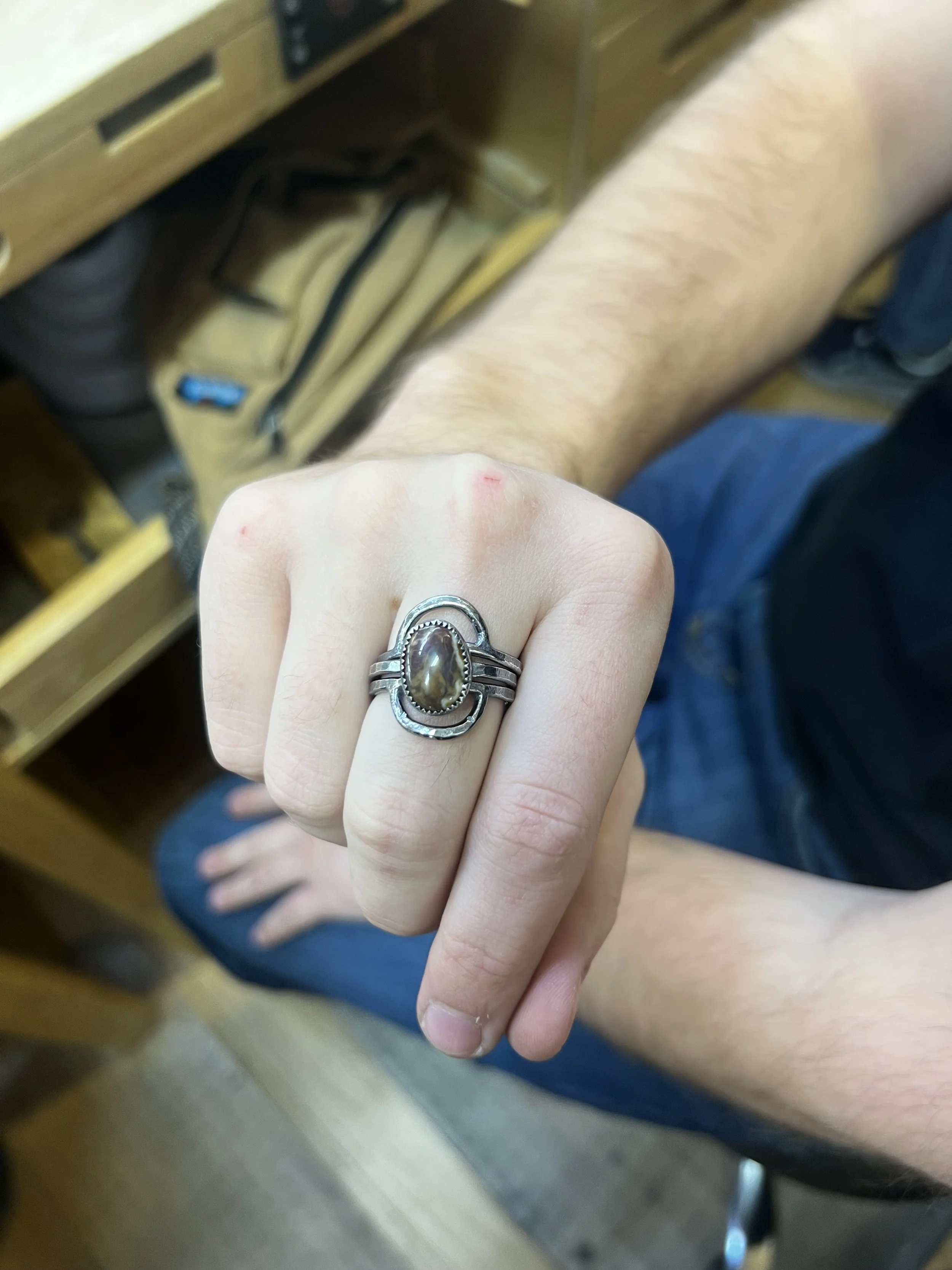 Student displaying a handcrafted turquoise ring from a turquoise ring class in Albuquerque