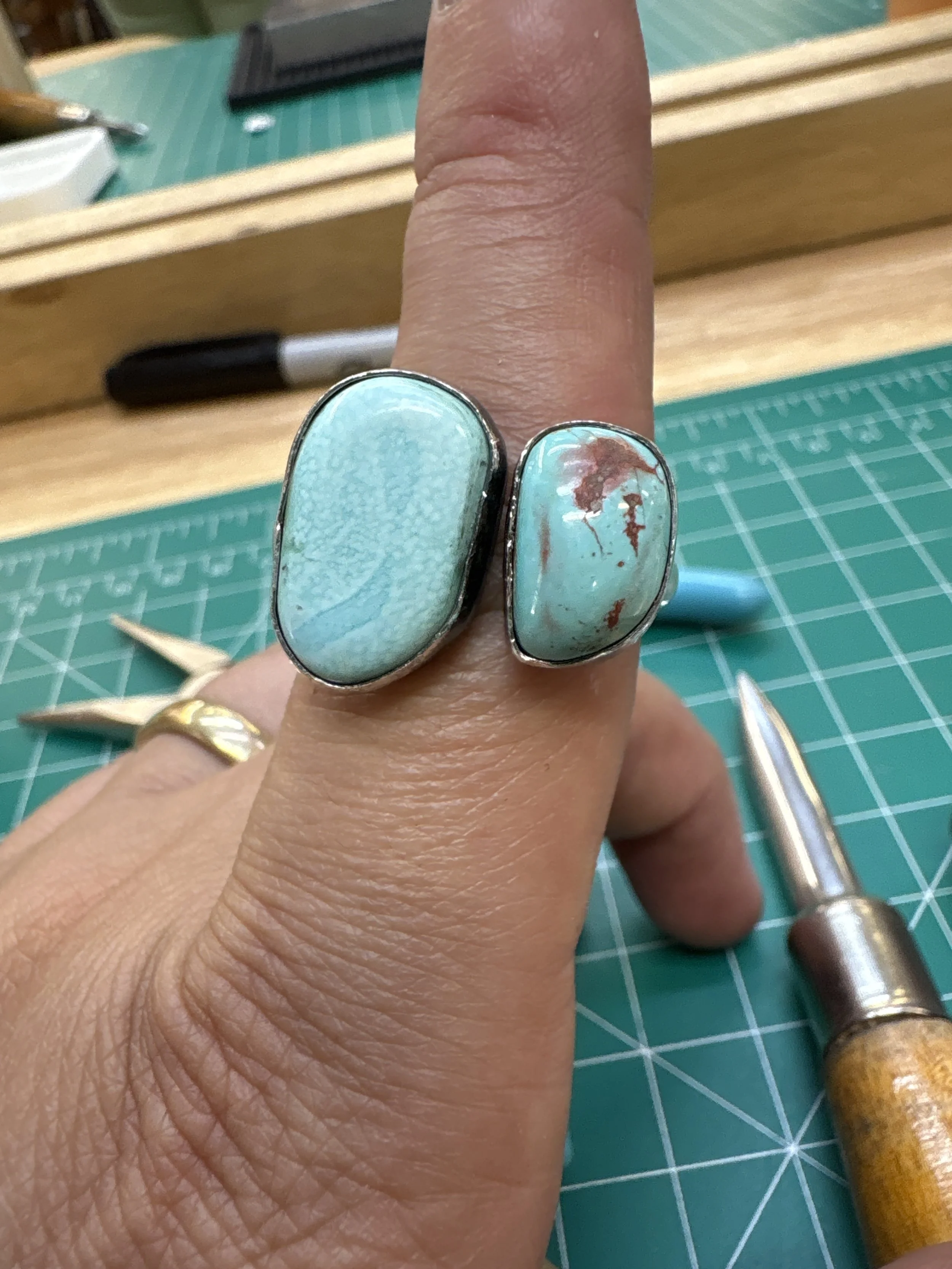 Student displaying a handcrafted turquoise ring from a turquoise ring class in Albuquerque