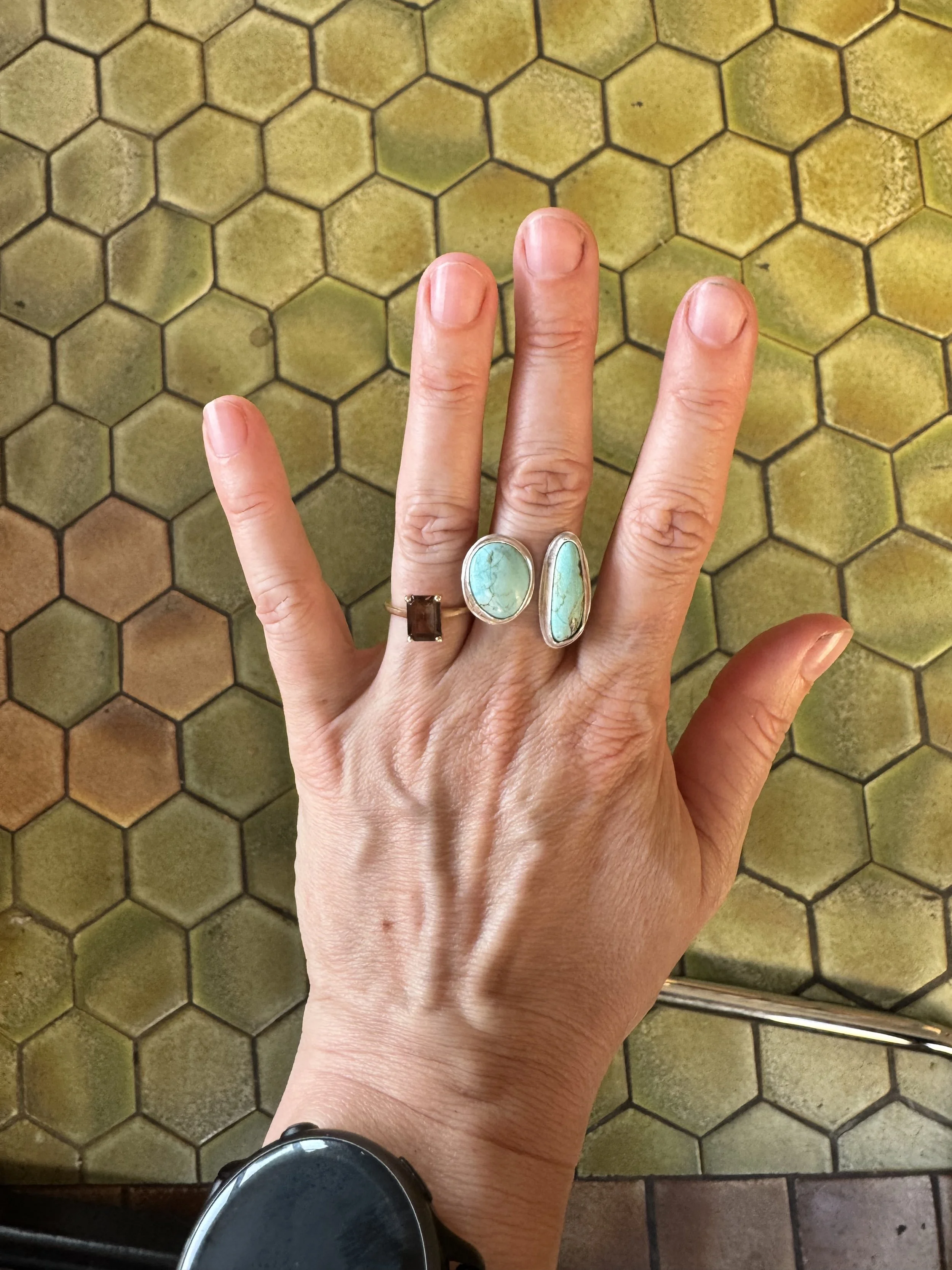 Hand showing a finished turquoise ring made during a turquoise ring class in Albuquerque