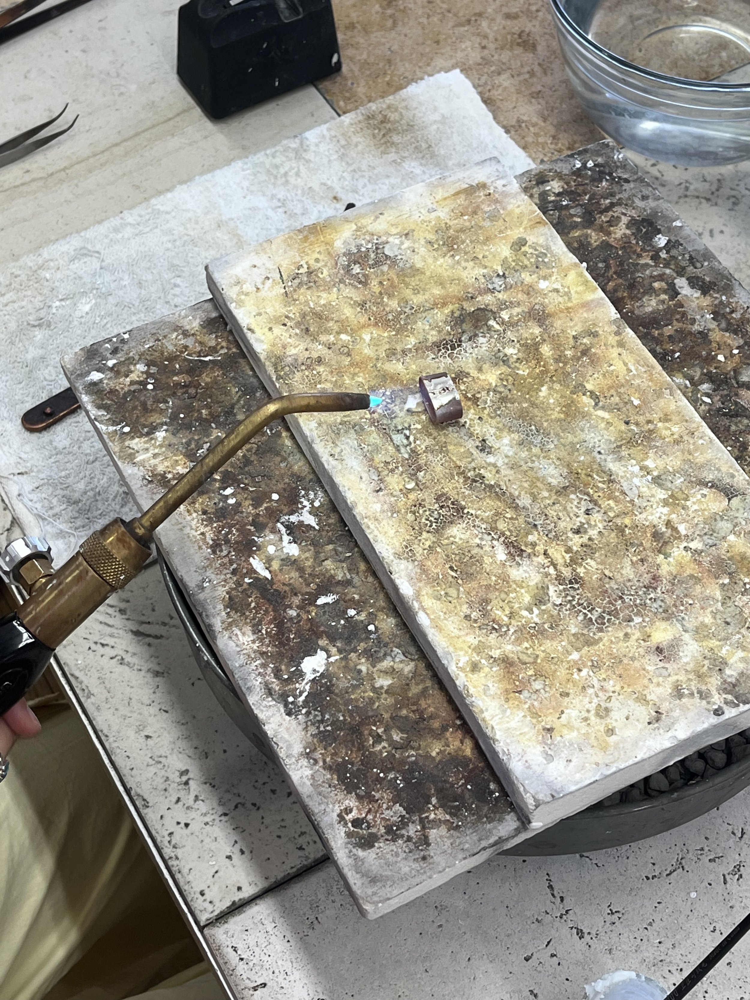 Torch soldering a sterling silver ring during a jewelry making class in Albuquerque
