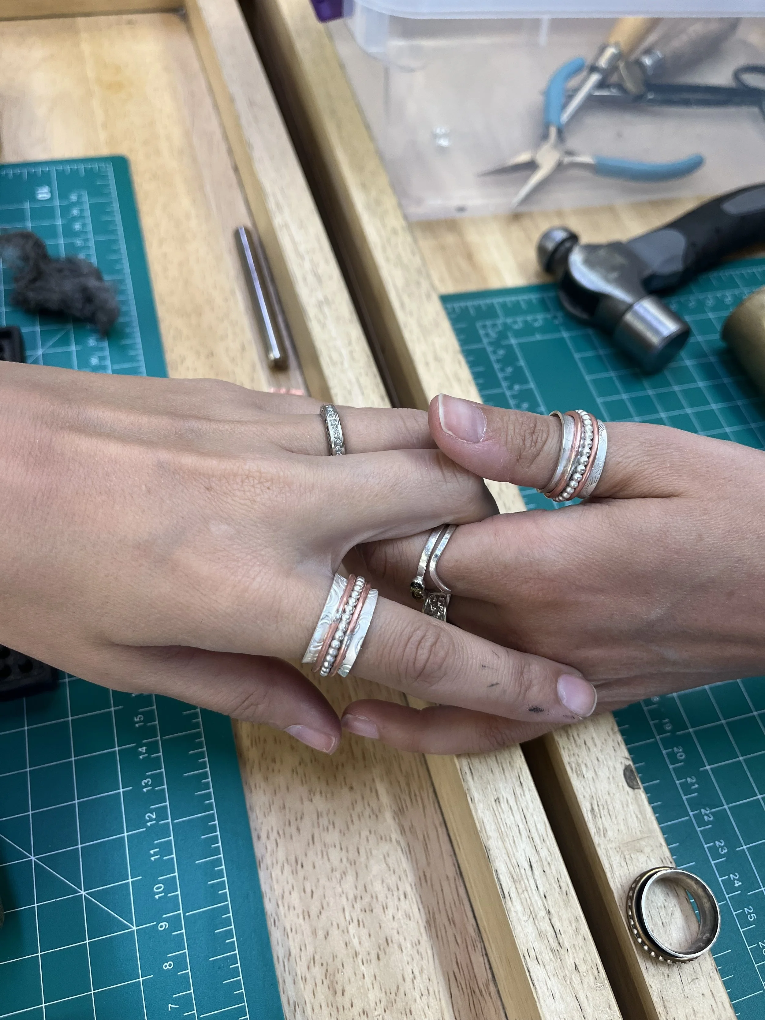 Hands shaping and fitting a ring during a jewelry making class in Albuquerque