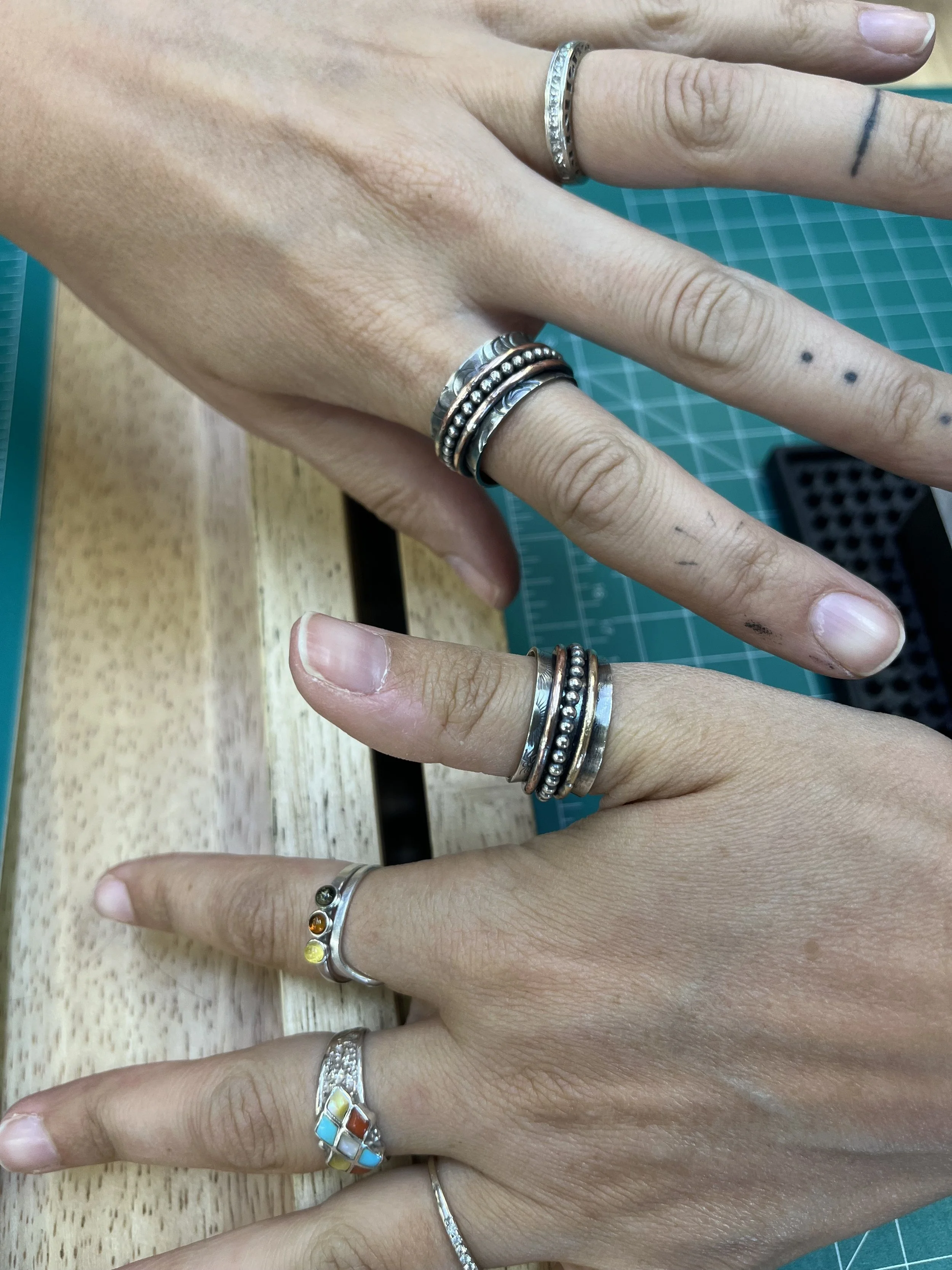 Finished spinner rings worn on hand after a jewelry making class in Albuquerque