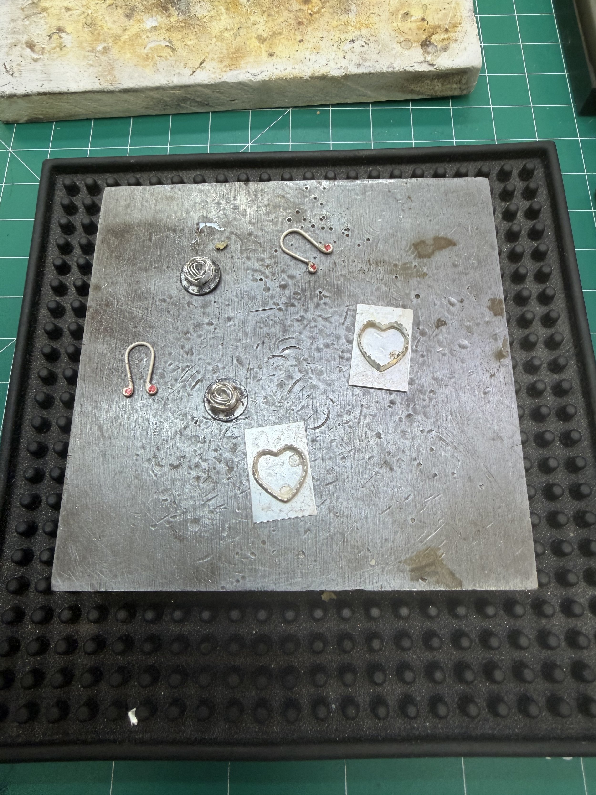 Metal tray with soldered silver components and heart shapes during a jewelry workshop in Albuquerque