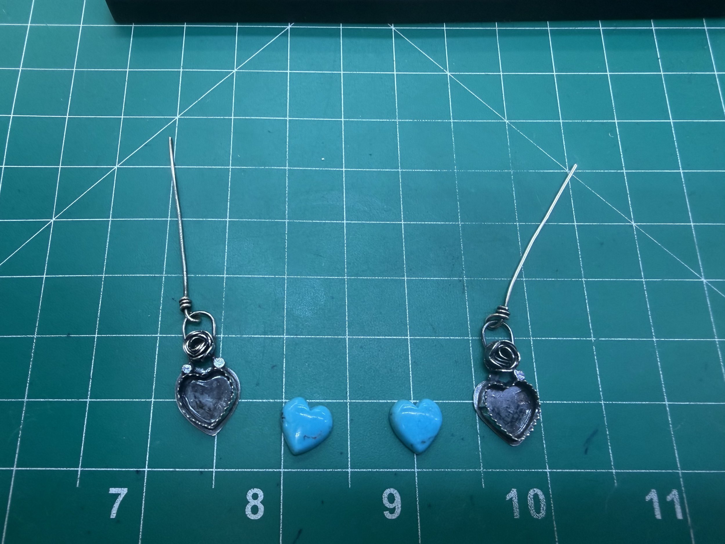 Finished sterling silver heart earrings with turquoise stones made in a jewelry workshop in Albuquerque