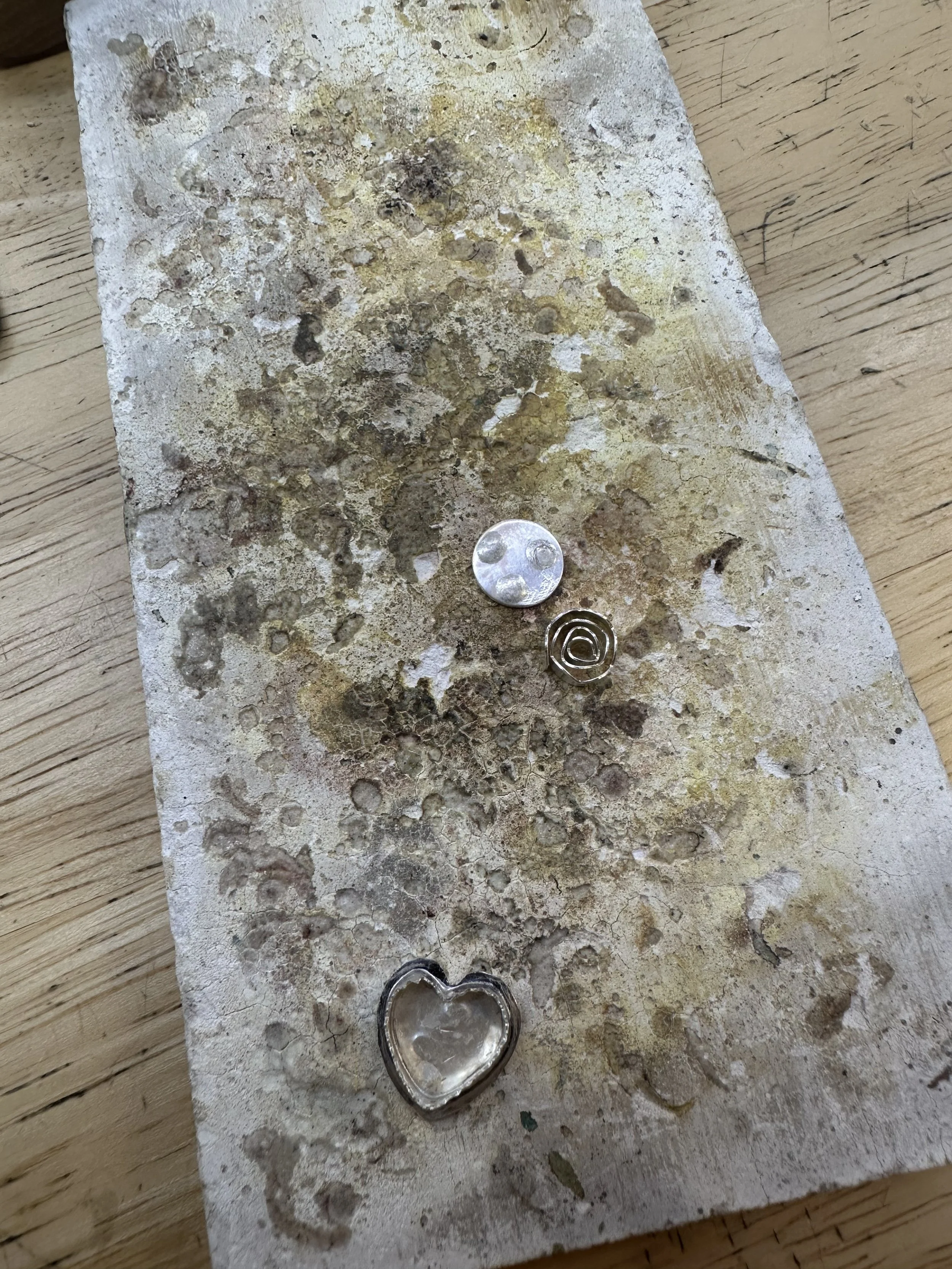 Jewelry workbench with metal dust and pendant in progress, jewelry making class Albuquerque studio