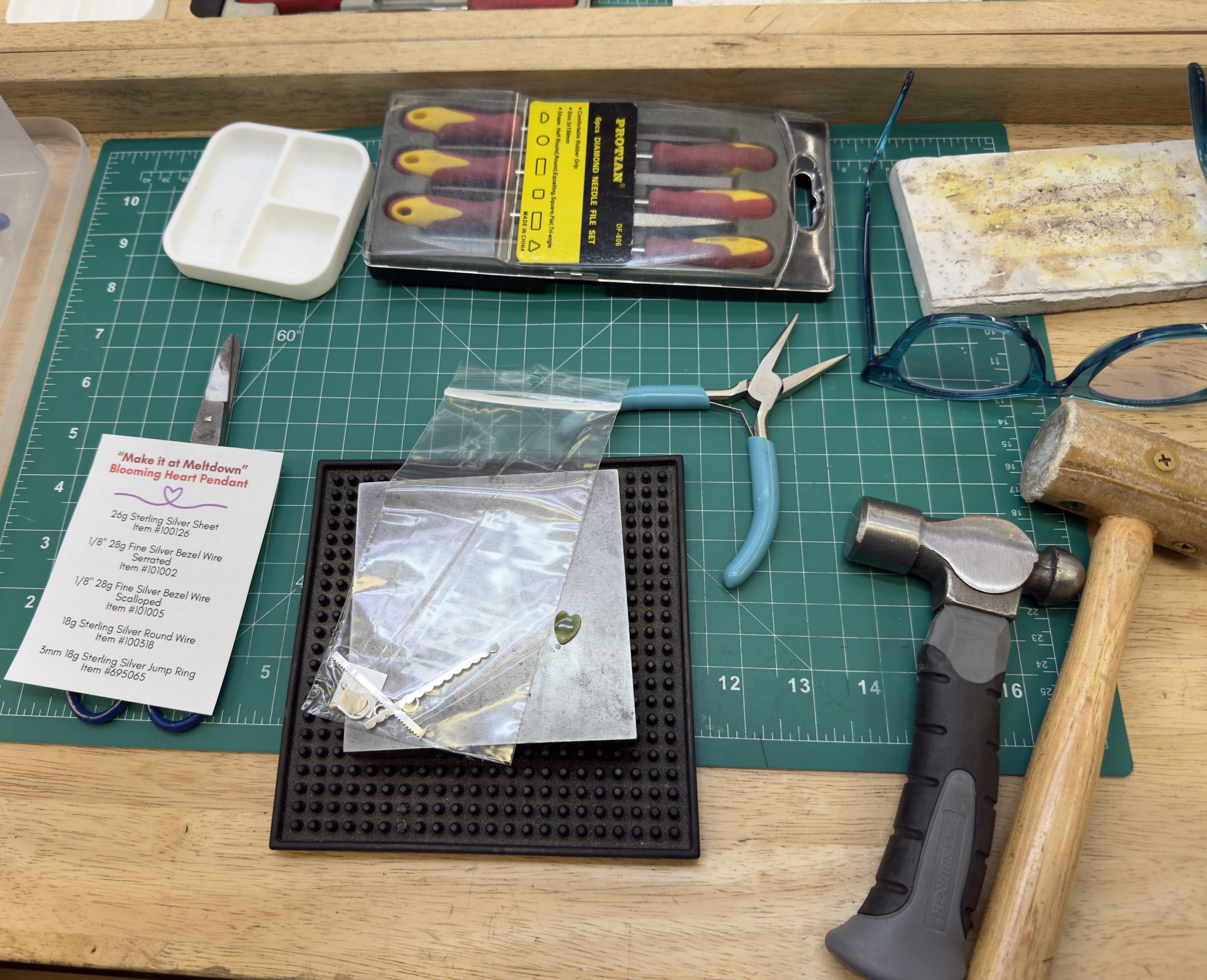 Beginner jewelry kit with silver sheet and tools on bench, jewelry making class Albuquerque