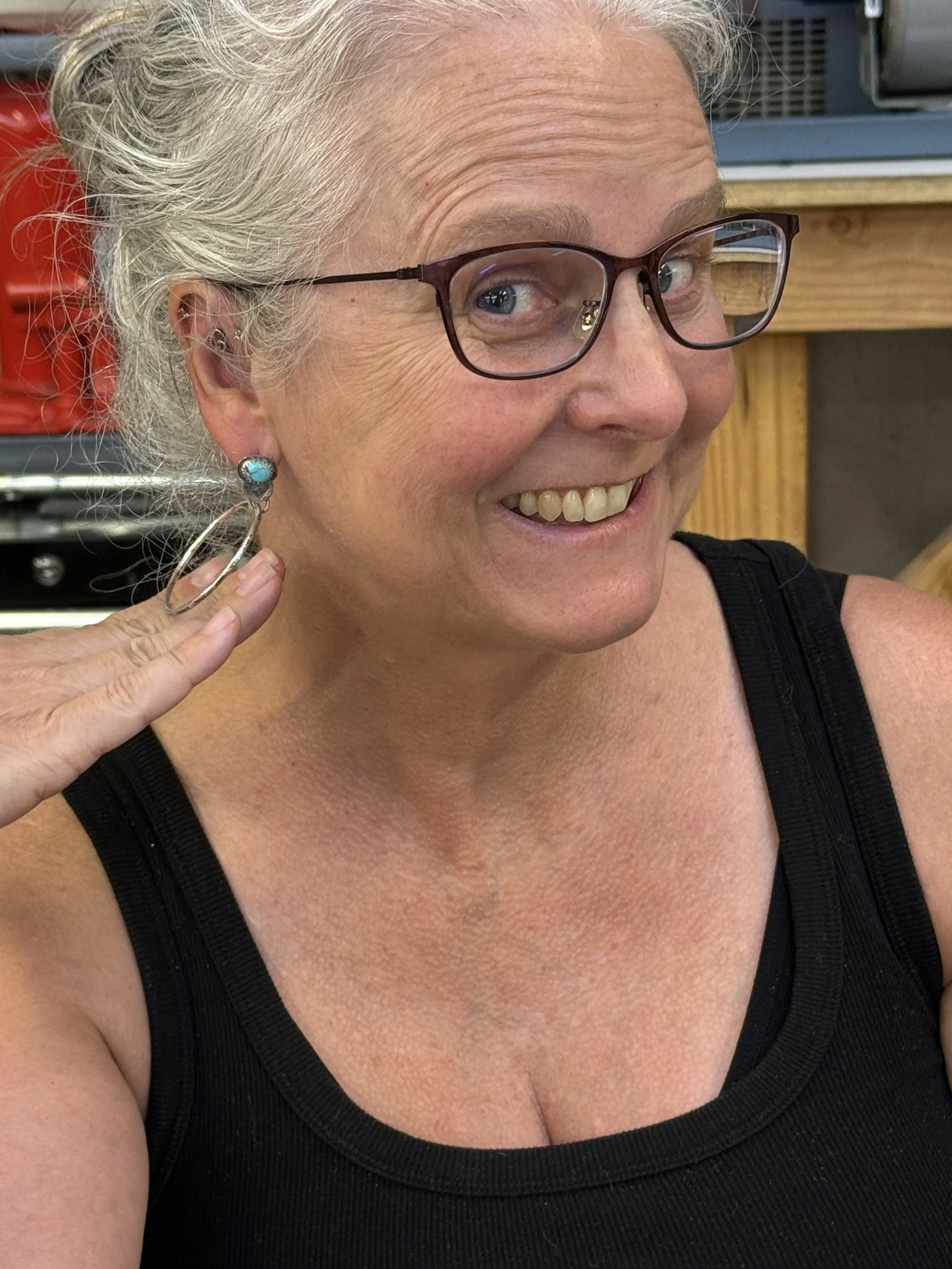 Student trying on turquoise hoop earrings from Jewelry Making Class in Albuquerque