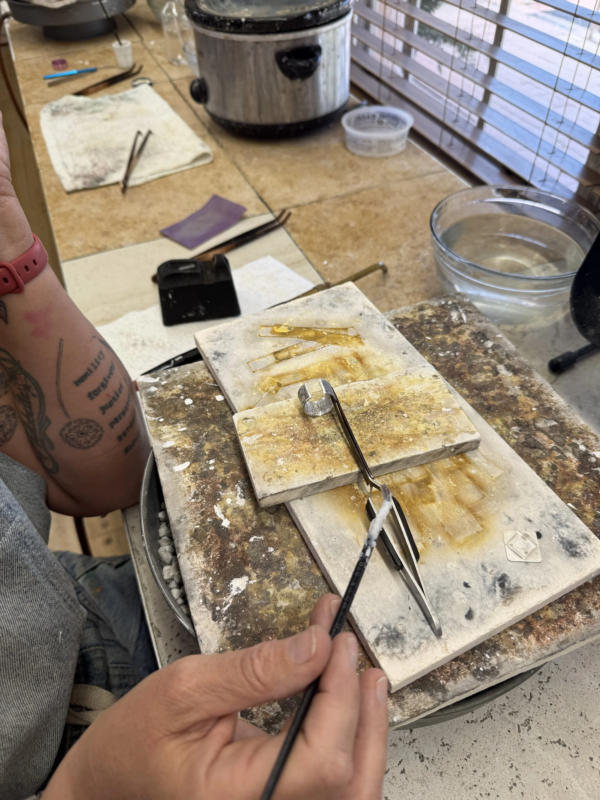 Turquoise ring class Albuquerque featuring a student working with jewelry tools at a workshop table.