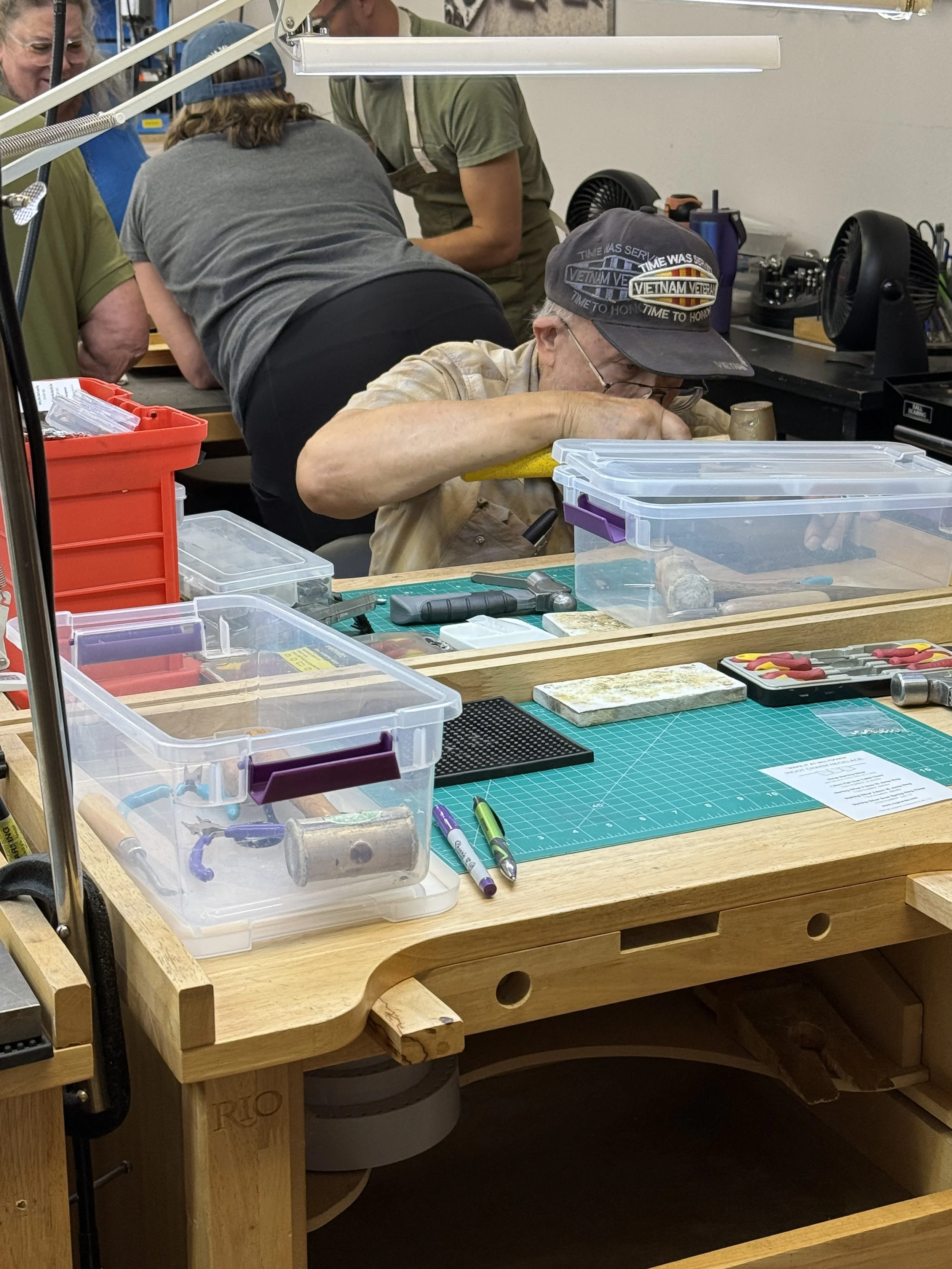 Jewelry making classes Albuquerque with students creating silver charms.