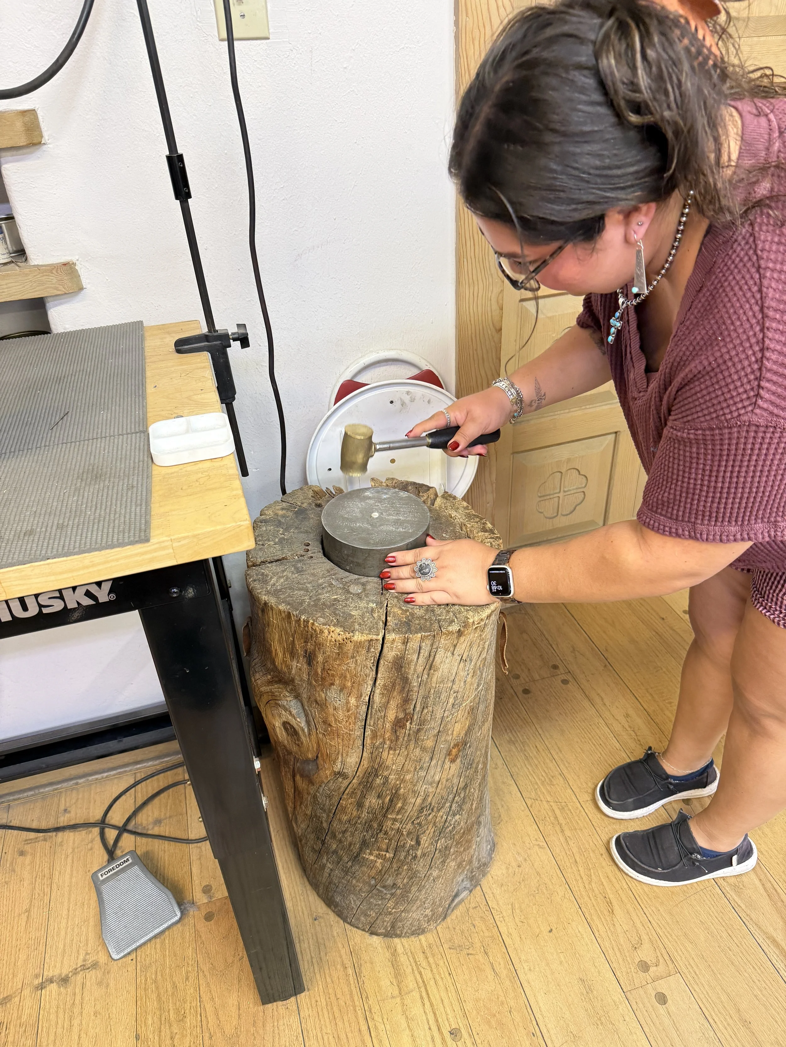 Jewelry making classes Albuquerque with a student working at the bench.