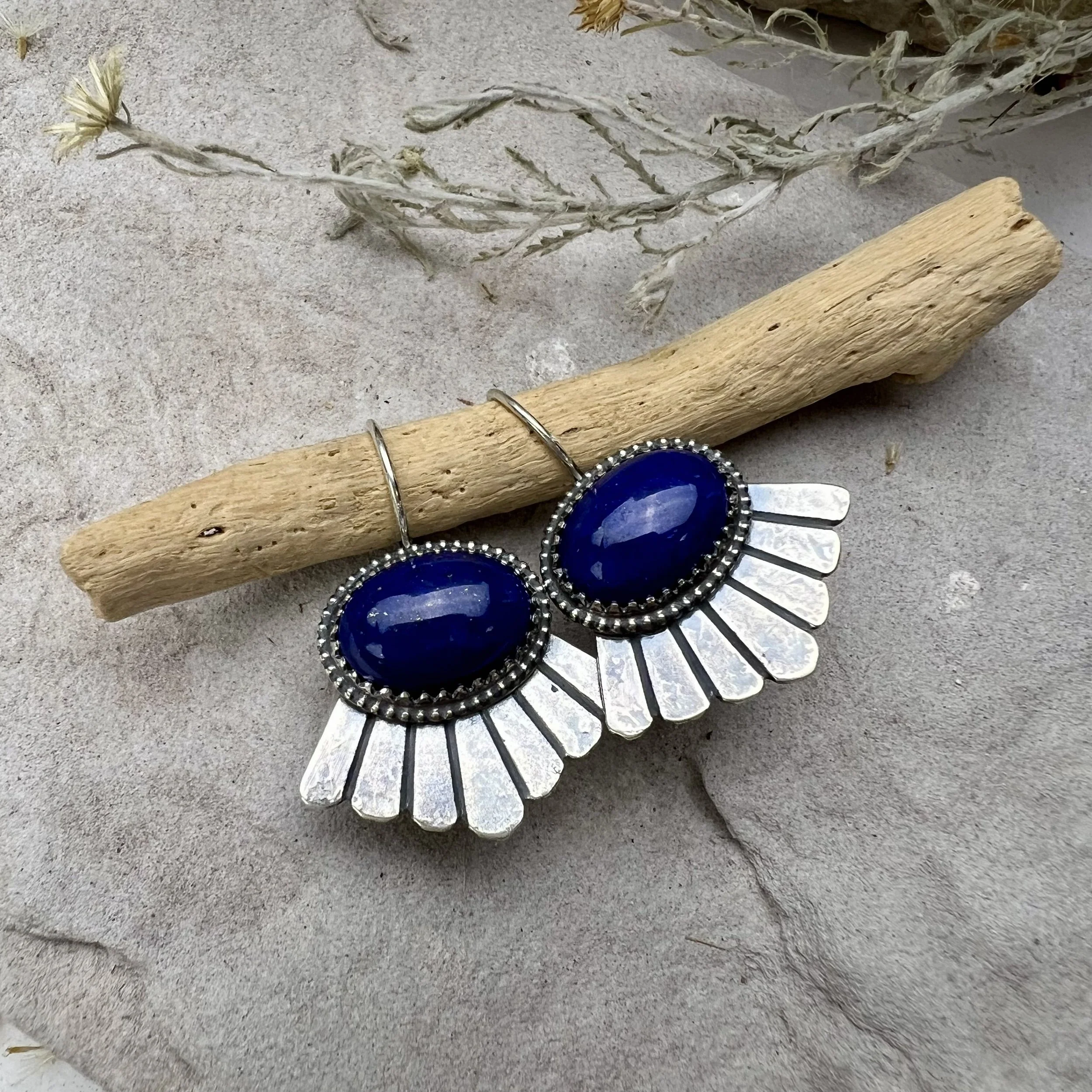 Sterling silver bezel being fitted around a lapis lazuli cabochon