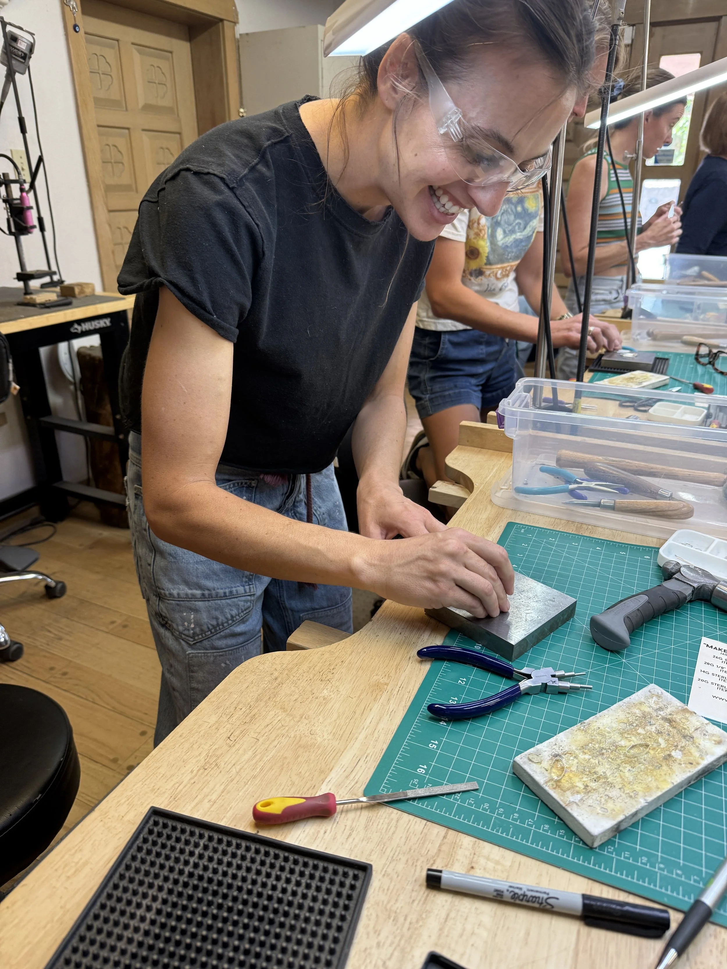 Student shaping silver at the jewelry-making bench