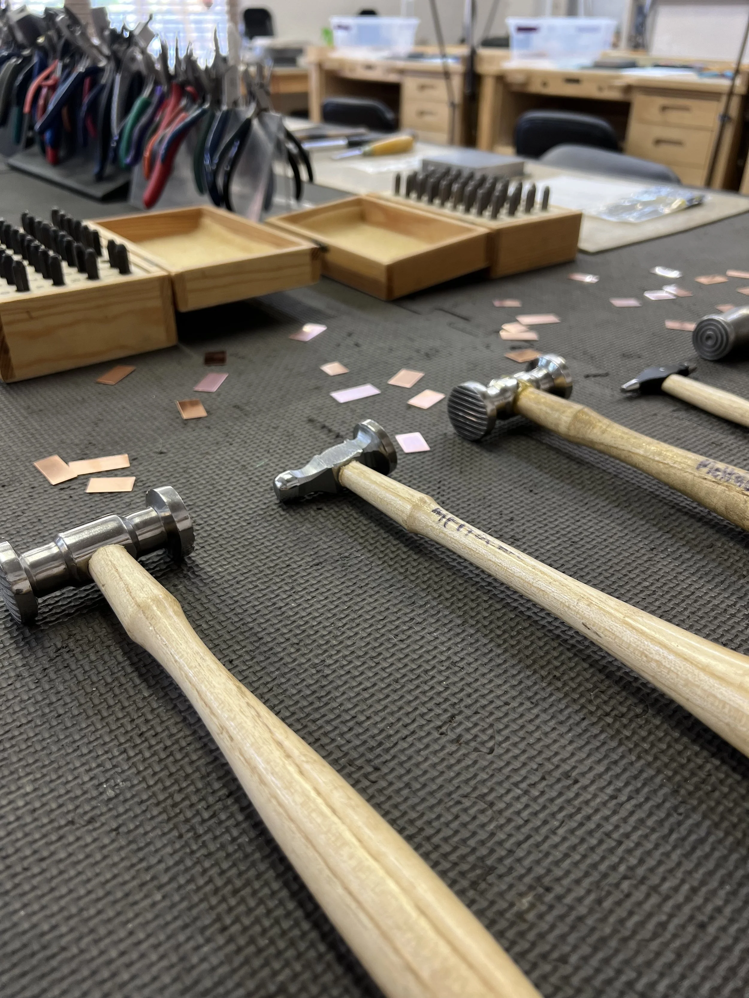 Jewelry-making hammers and tools on a workbench