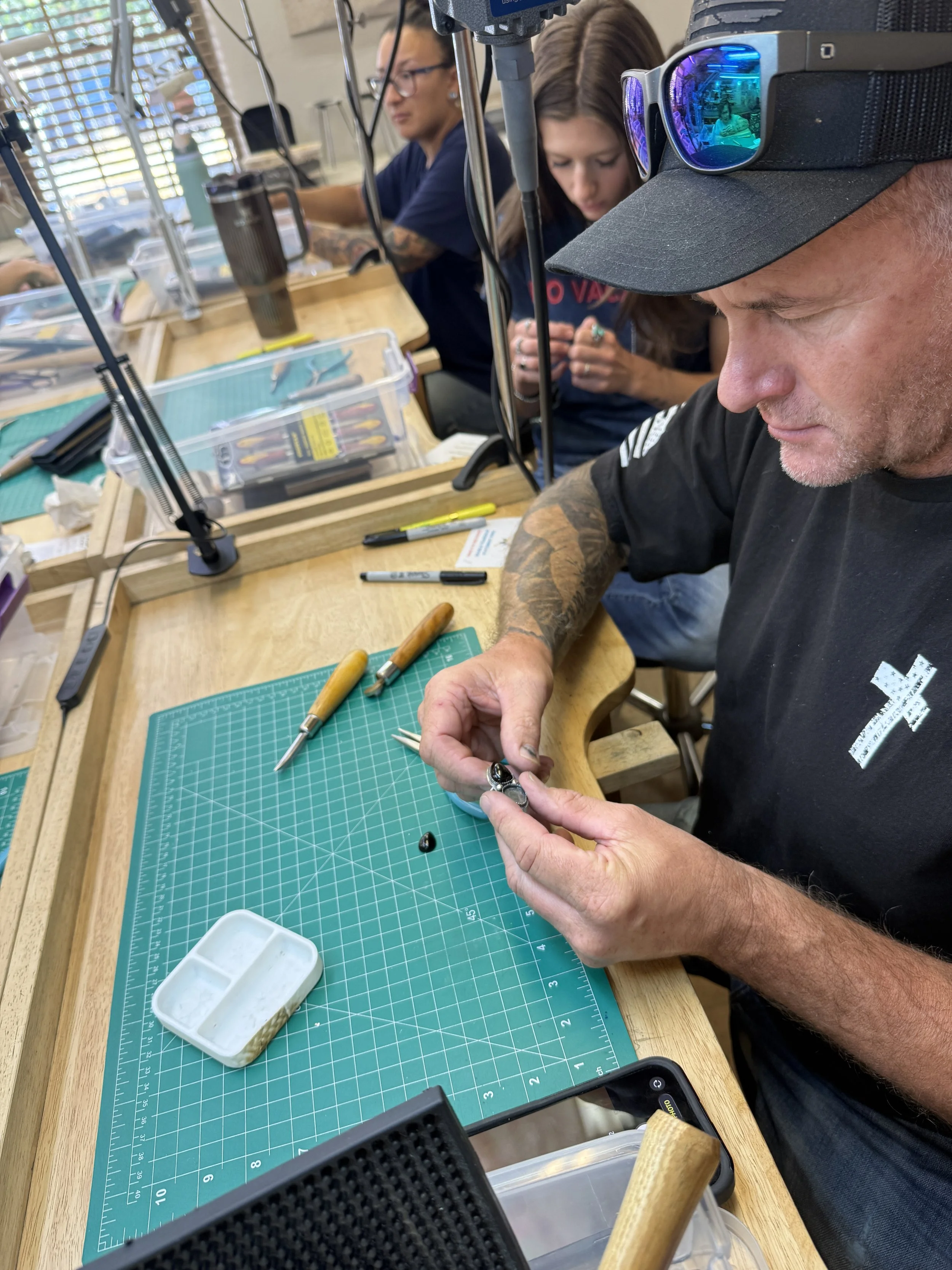 Student setting a stone into a ring at the workbench