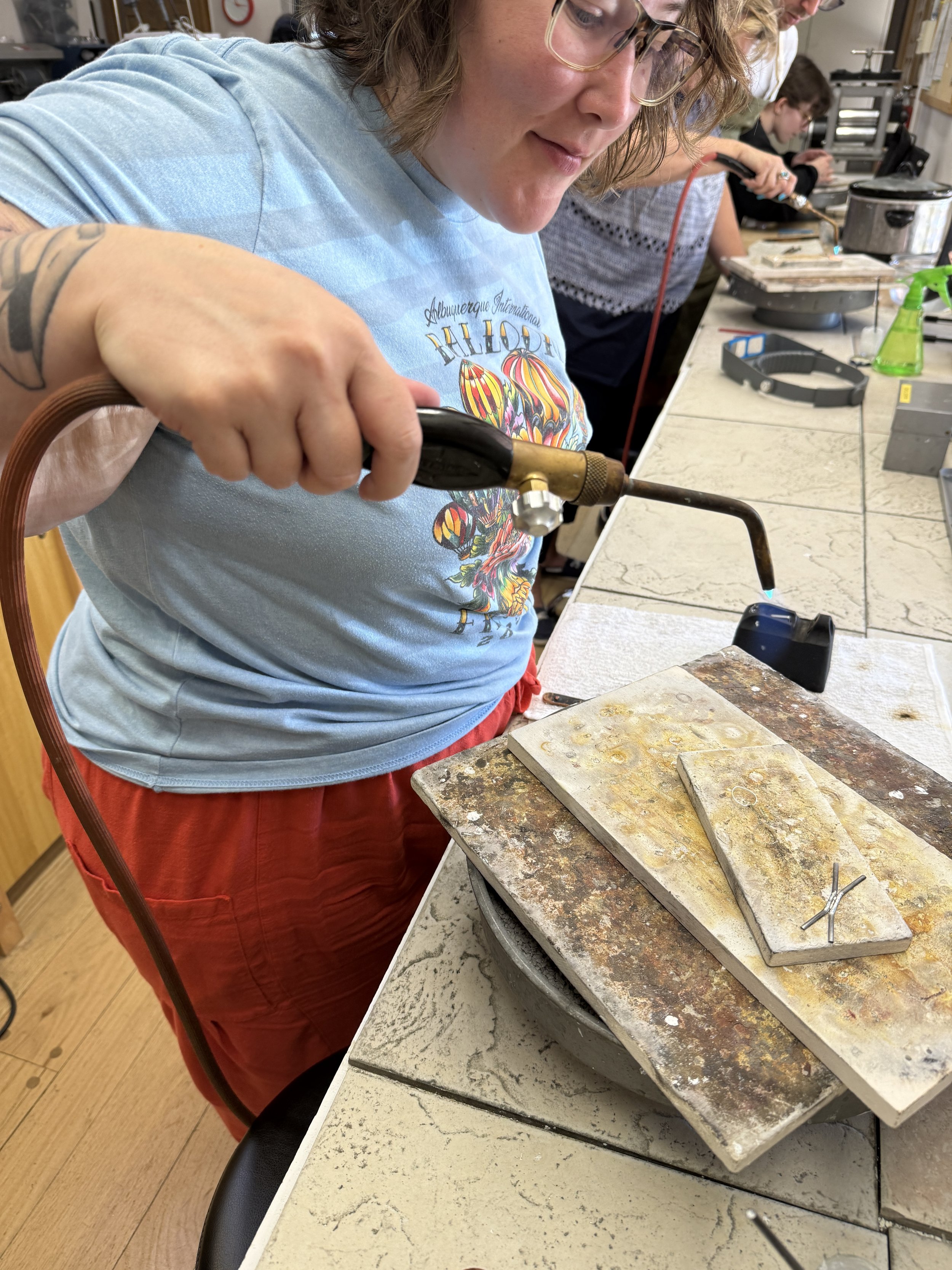 Student soldering a ring with a torch
