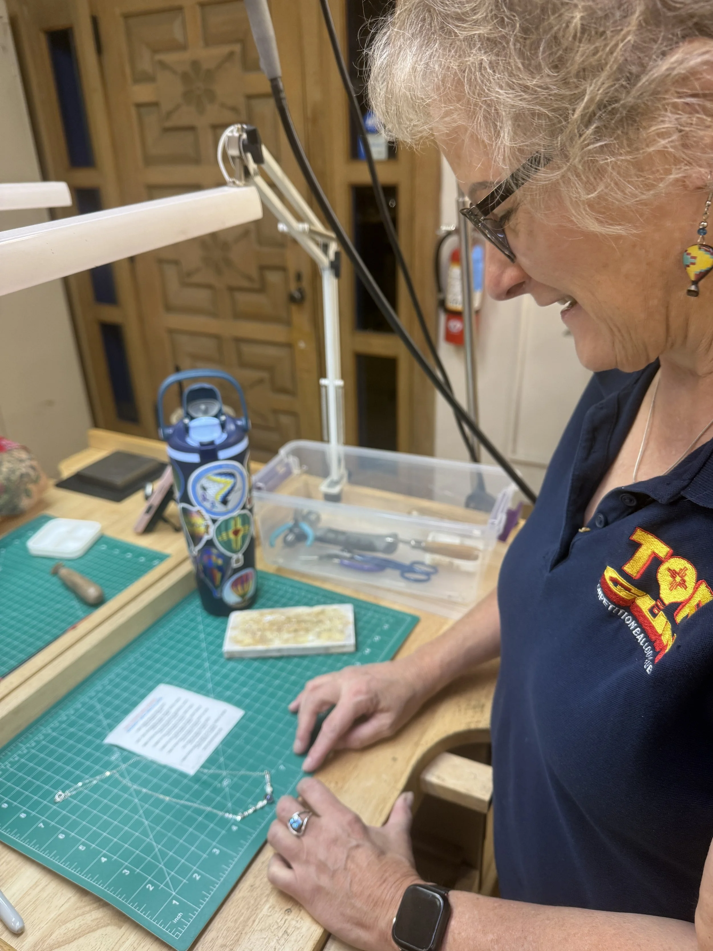 Student inspecting a necklace component at the workbench