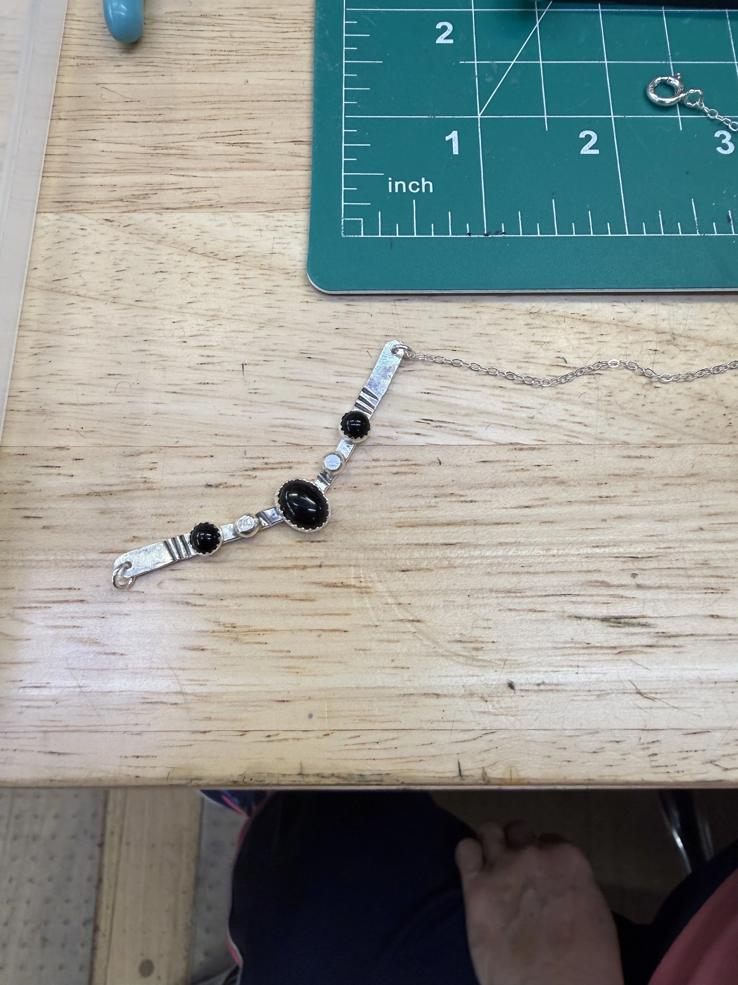Finished Desert Arc Necklace displayed on a workbench