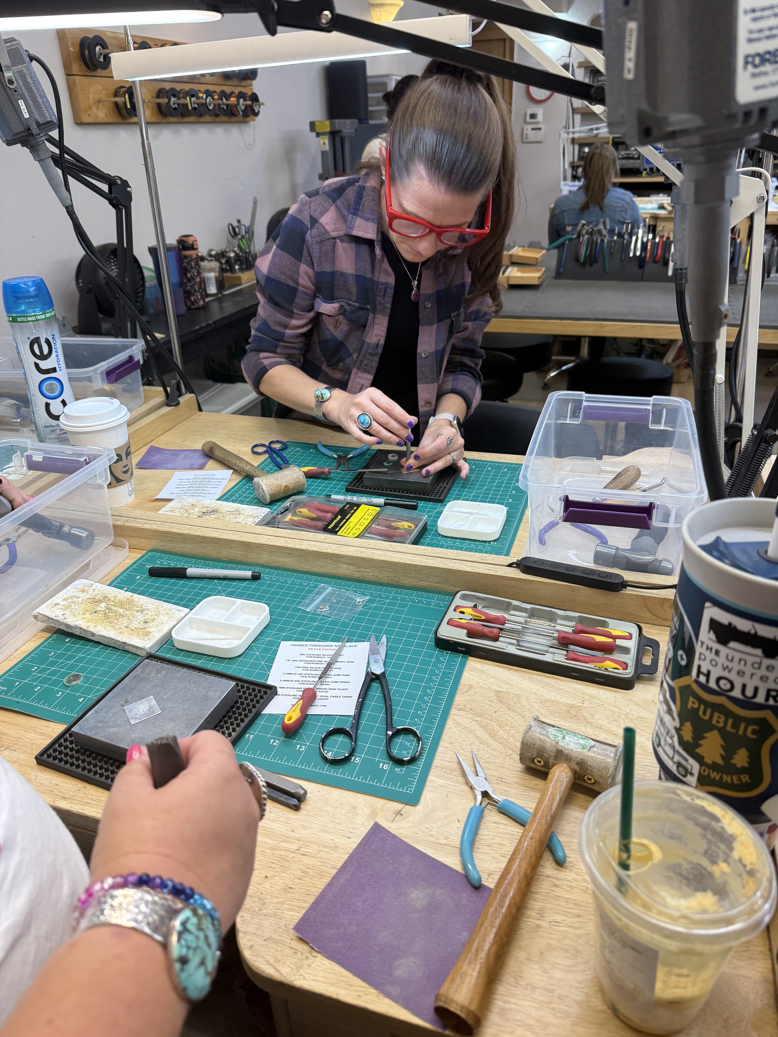 Student working on a jewelry piece at the workbench.