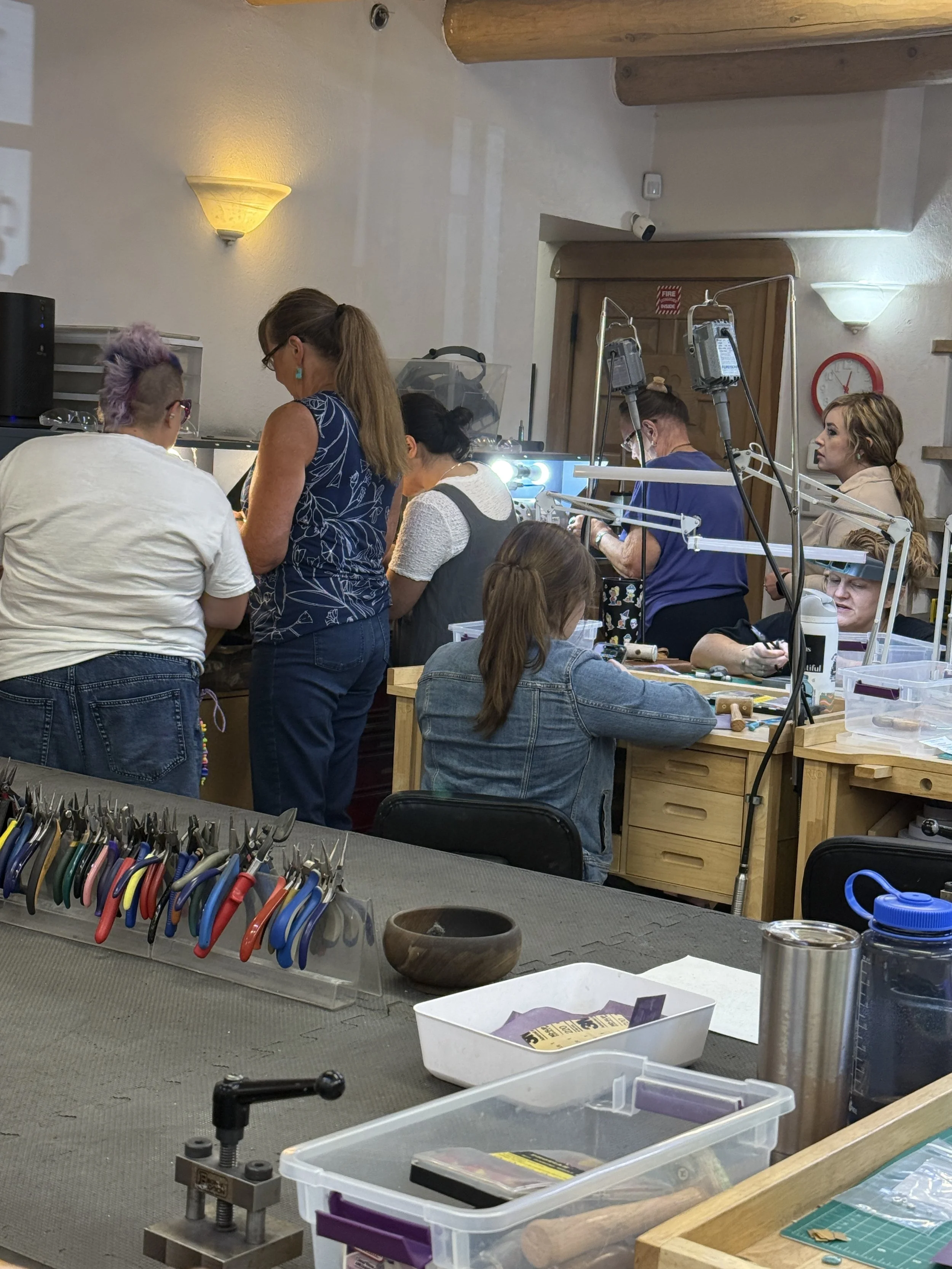 Students working on jewelry projects at the studio benches.