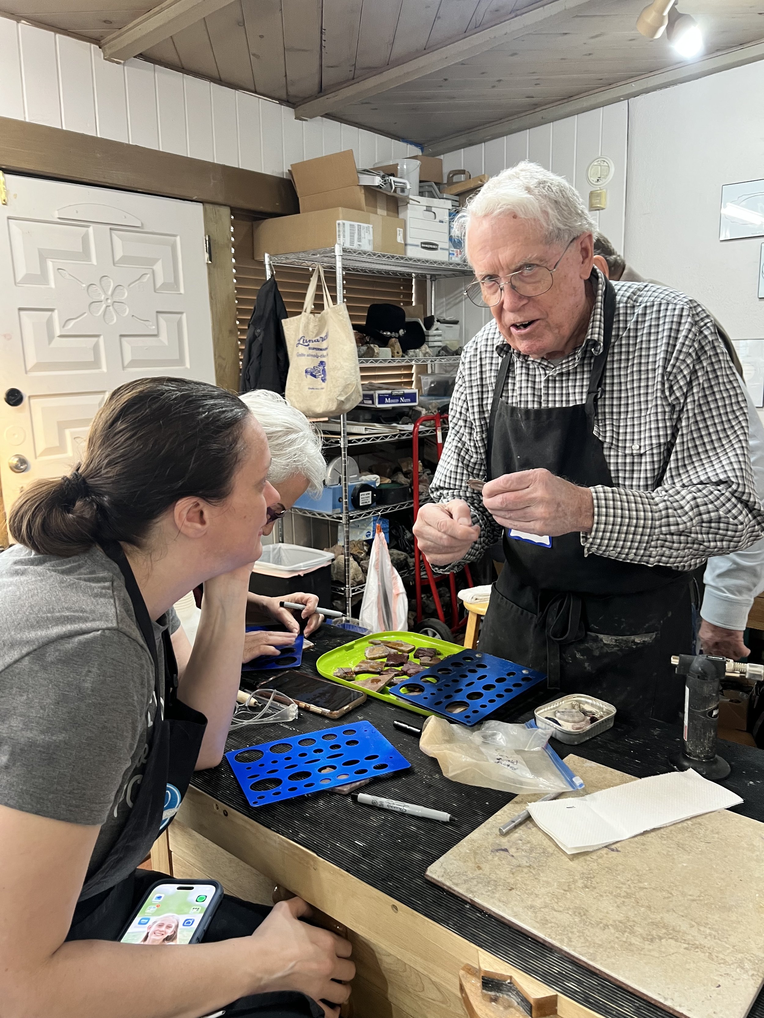 Instructor demonstrating jewelry-making tools to students.
