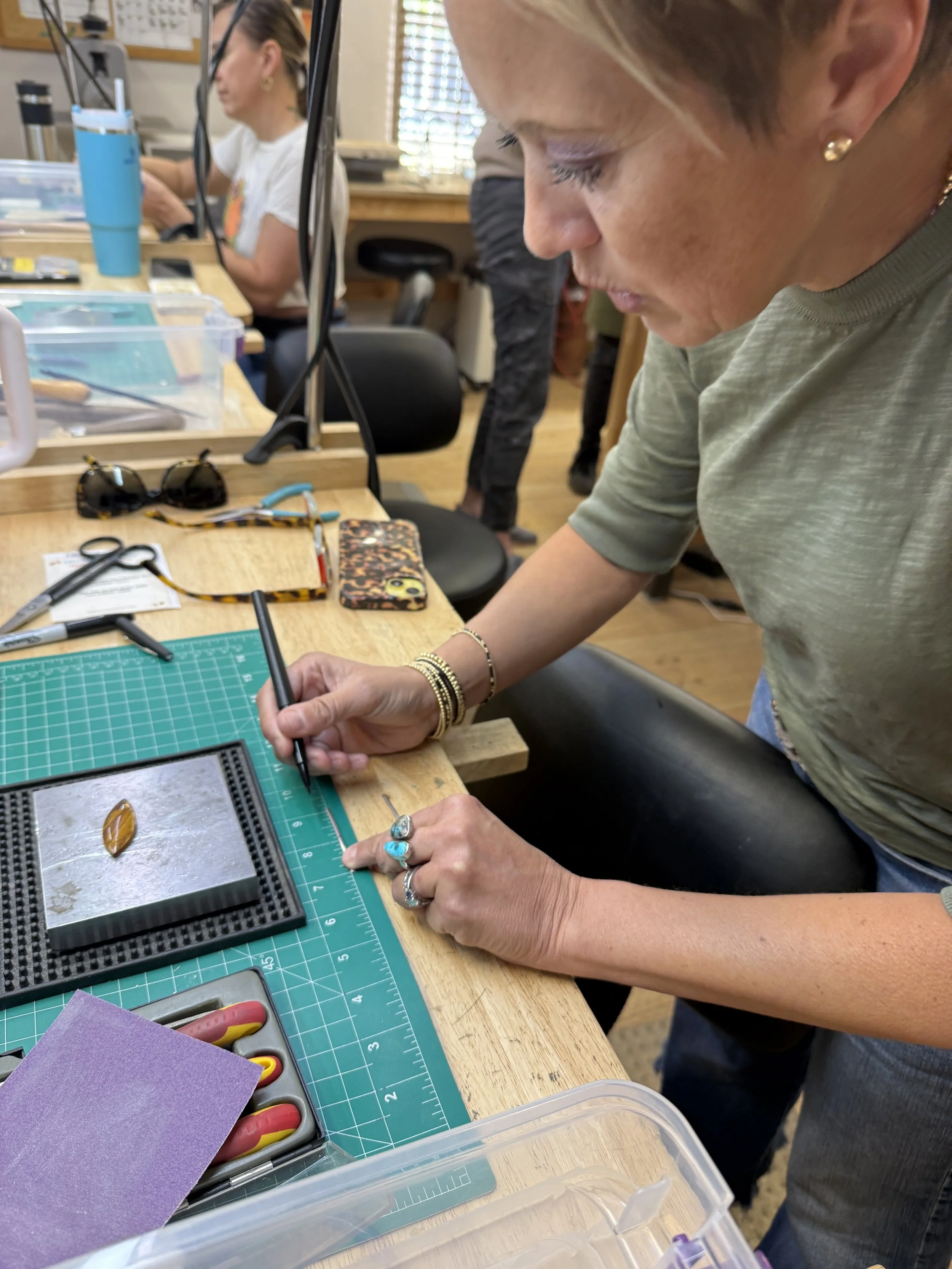 Student shaping and refining a stone with a hand tool