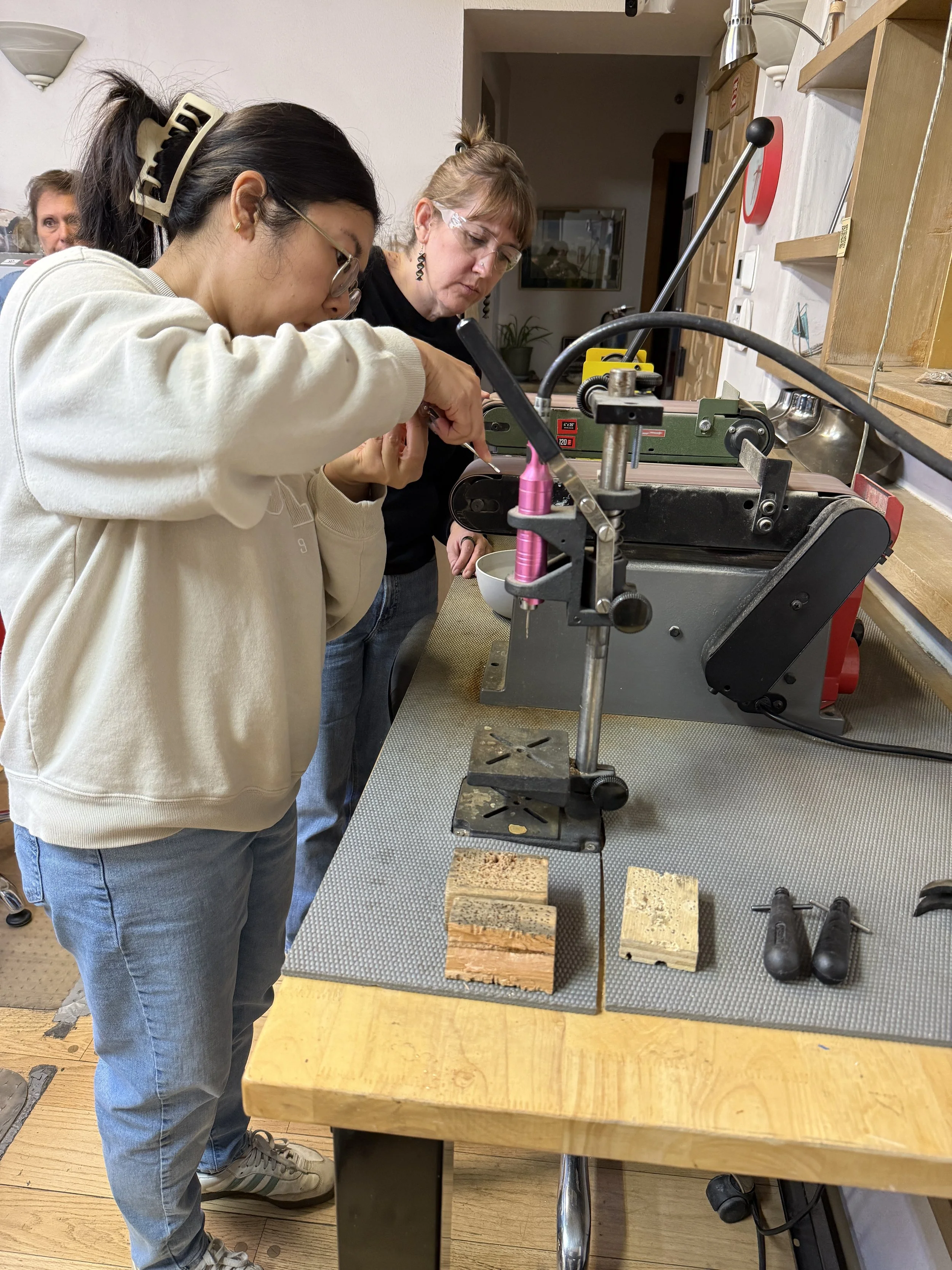 Student shaping a silver snake ring on a jewelry machine