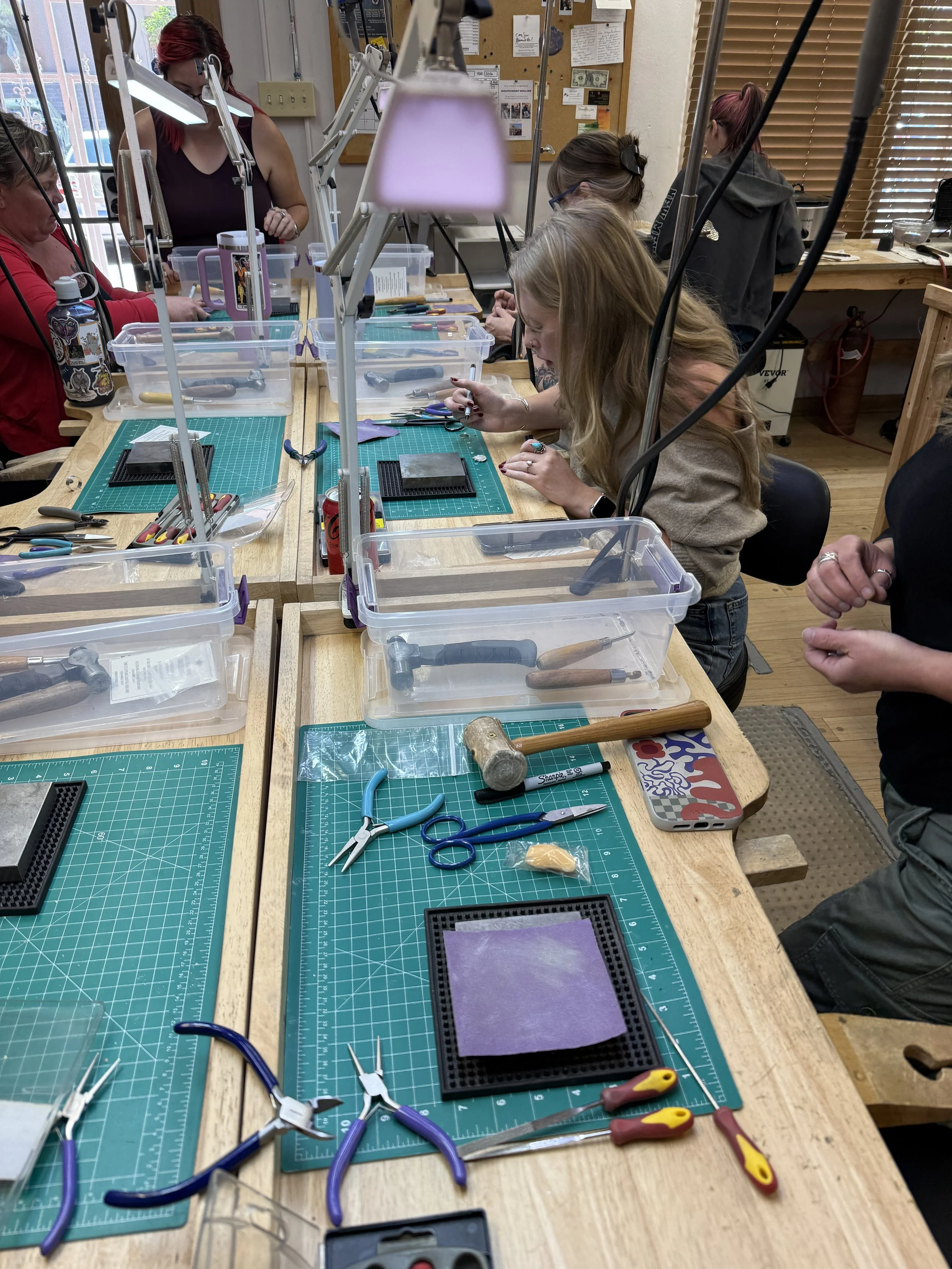 Student shaping a metal component with a hand tool