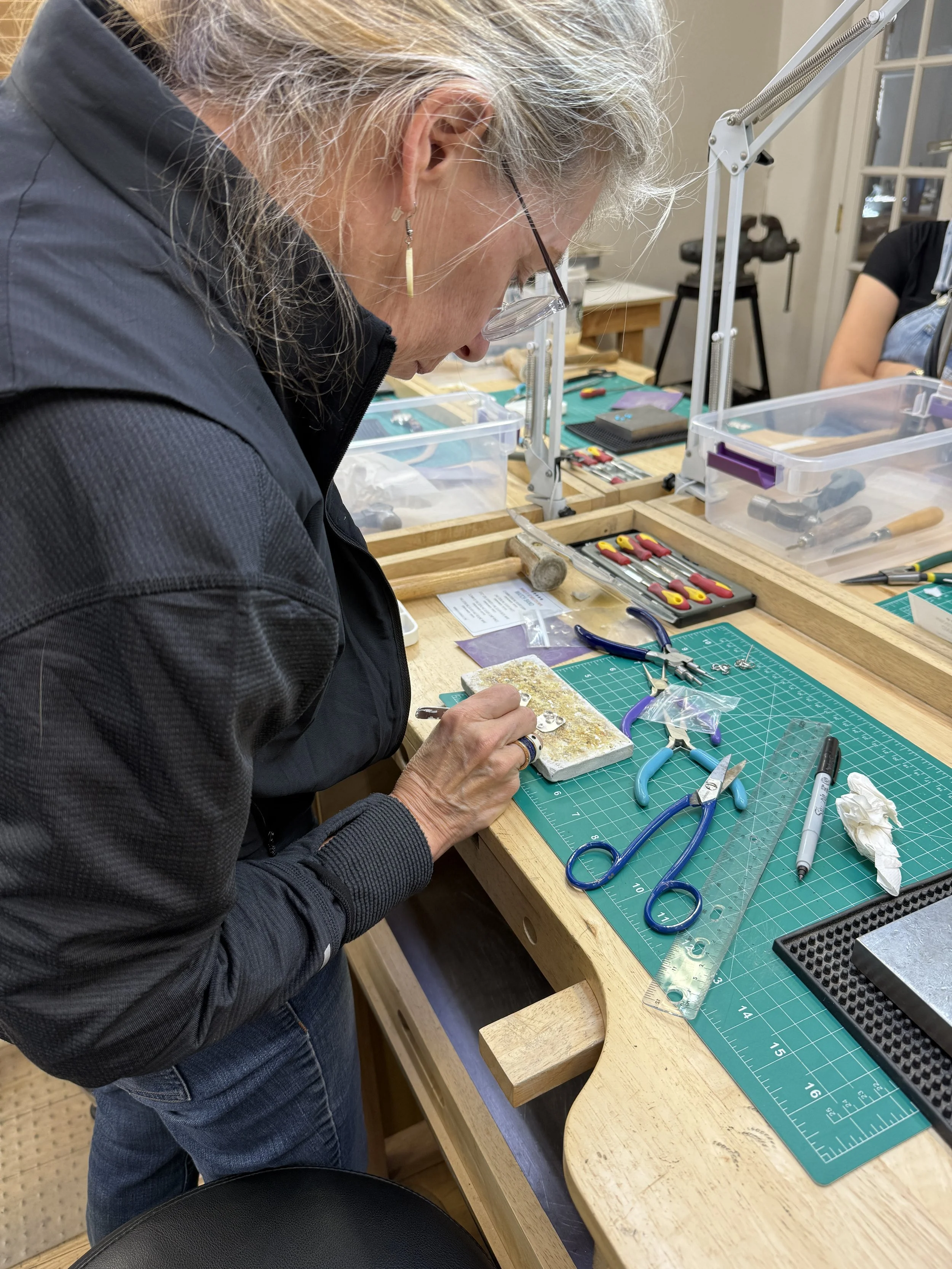 Filing and refining a metal jewelry component on a workbench