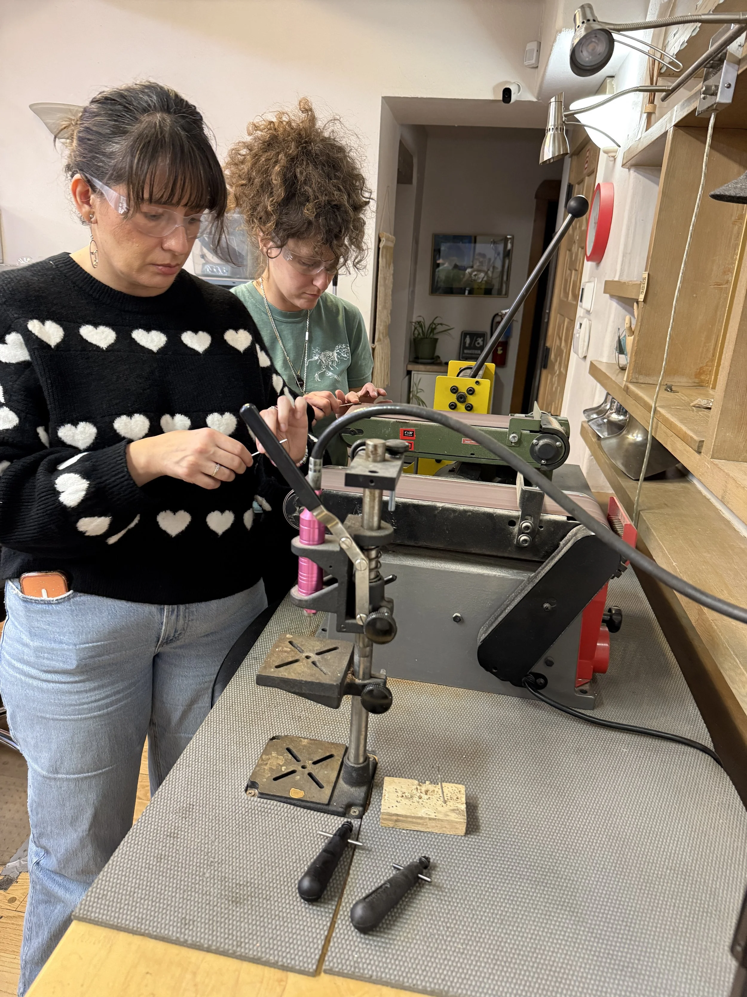 Students working with jewelry tools and equipment during a hands-on class