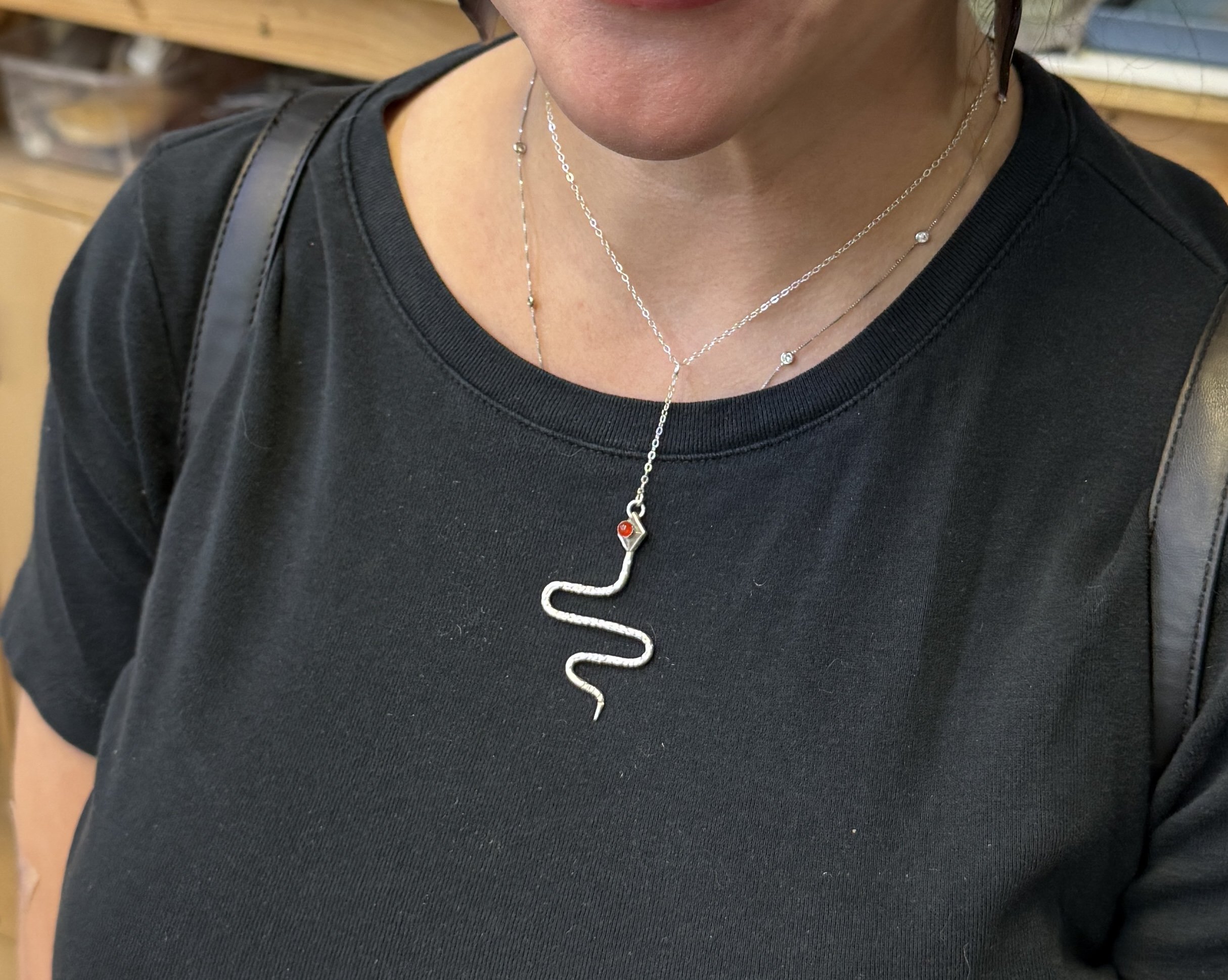 Finished silver snake necklace worn by a student after the class