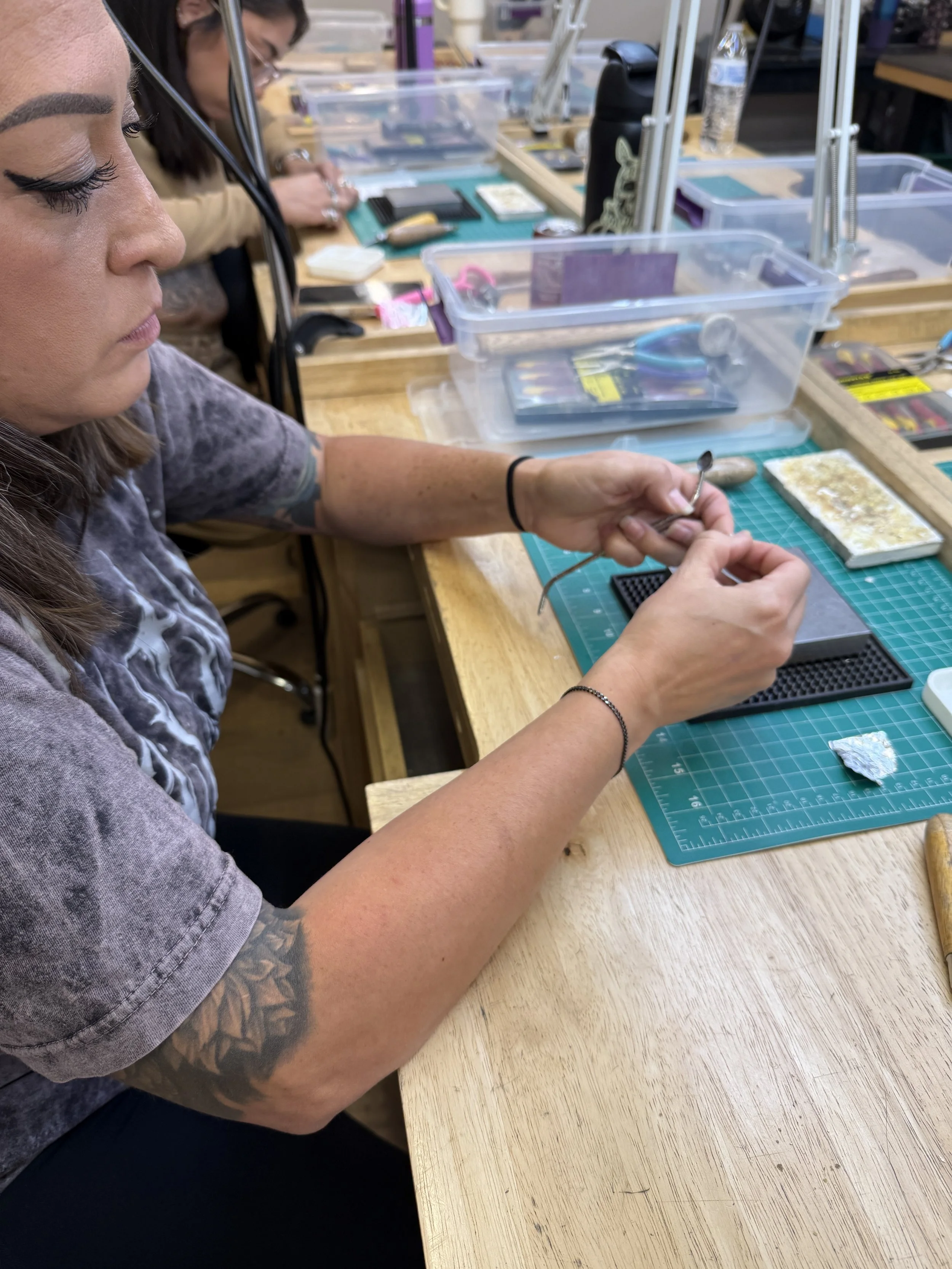 A student carefully shaping a small metal component by hand