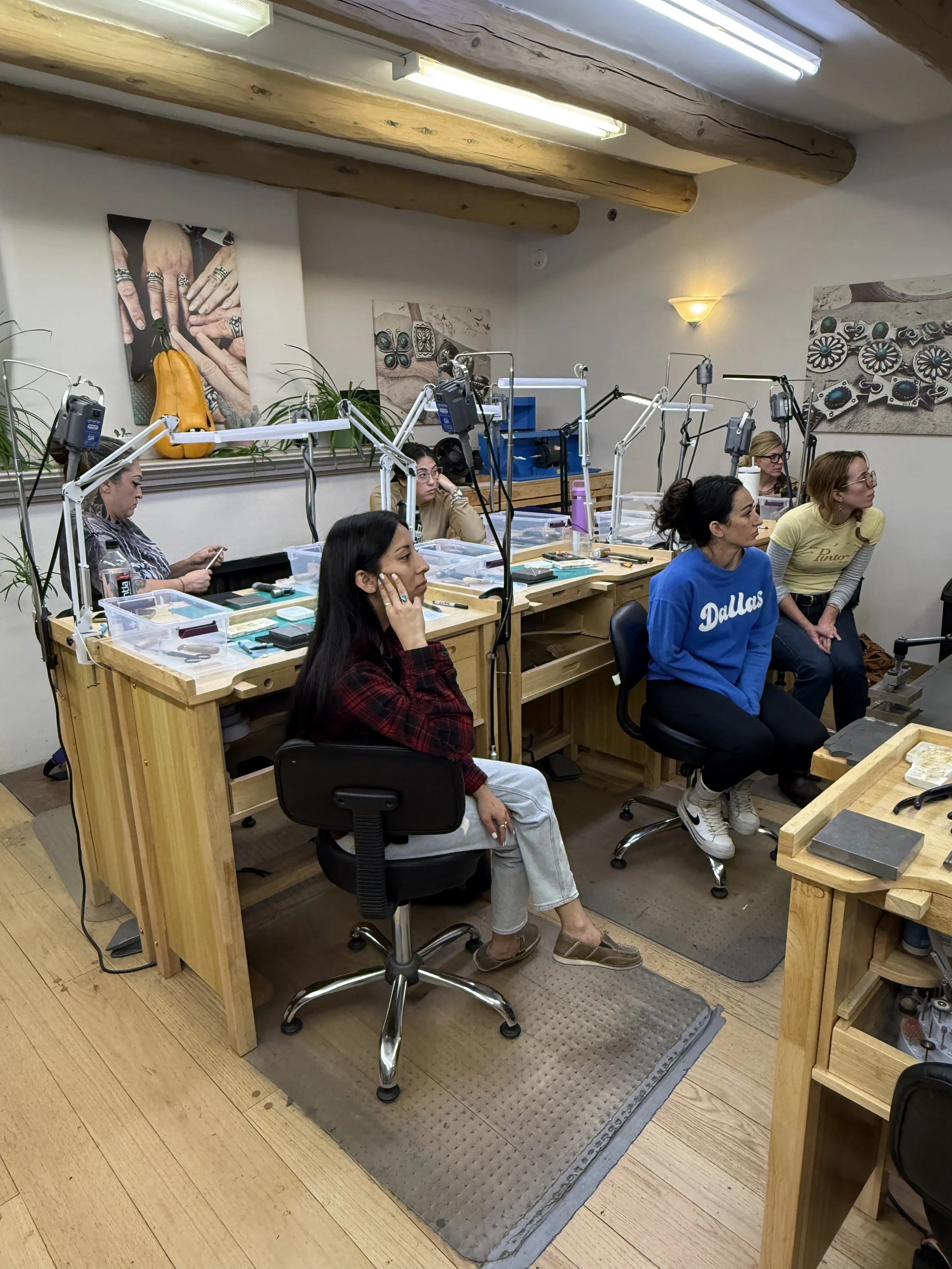 Students carefully listen during a jewelry-making class at Meltdown