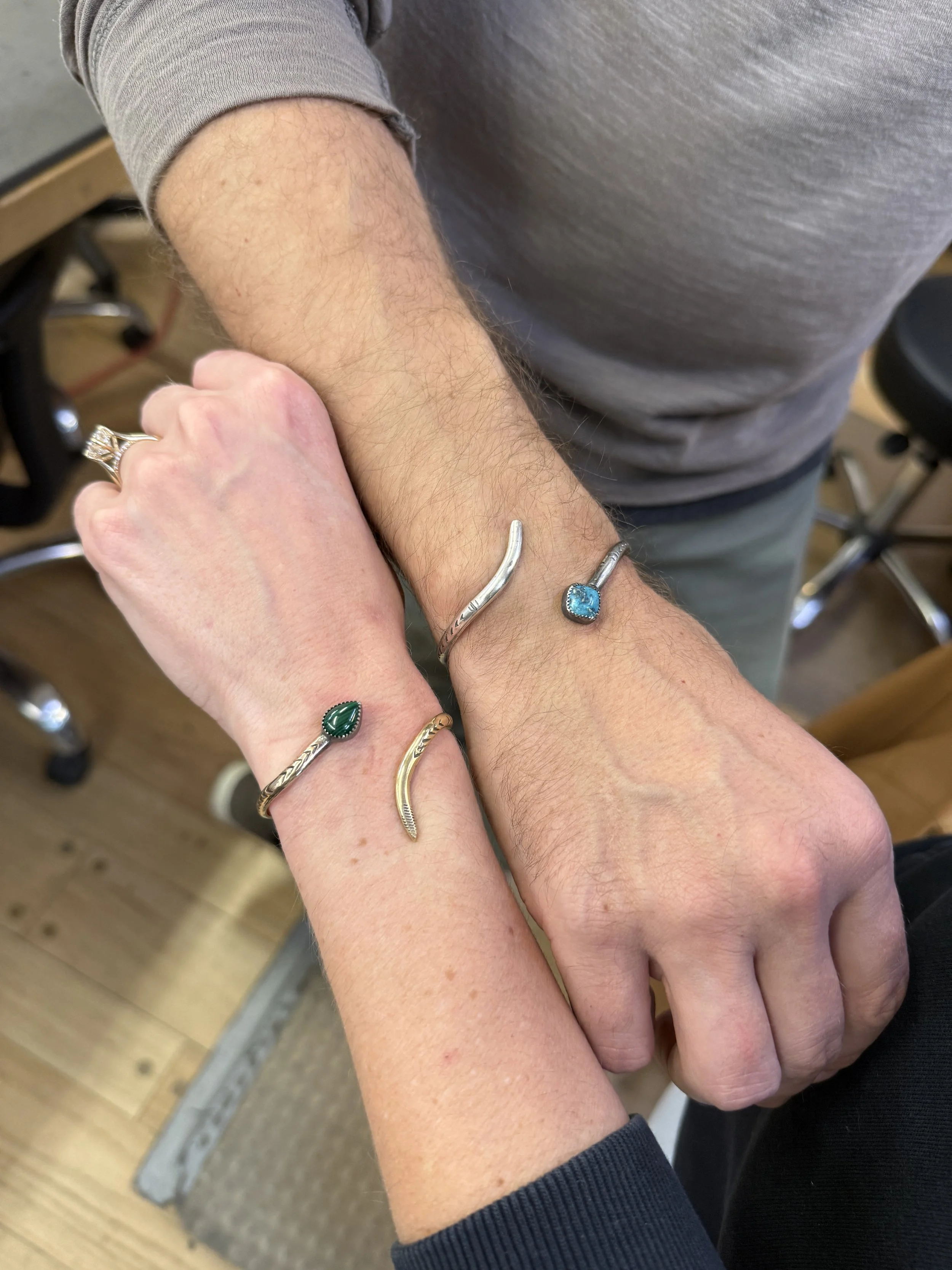 Close-up of two students modeling their finished snake bracelets