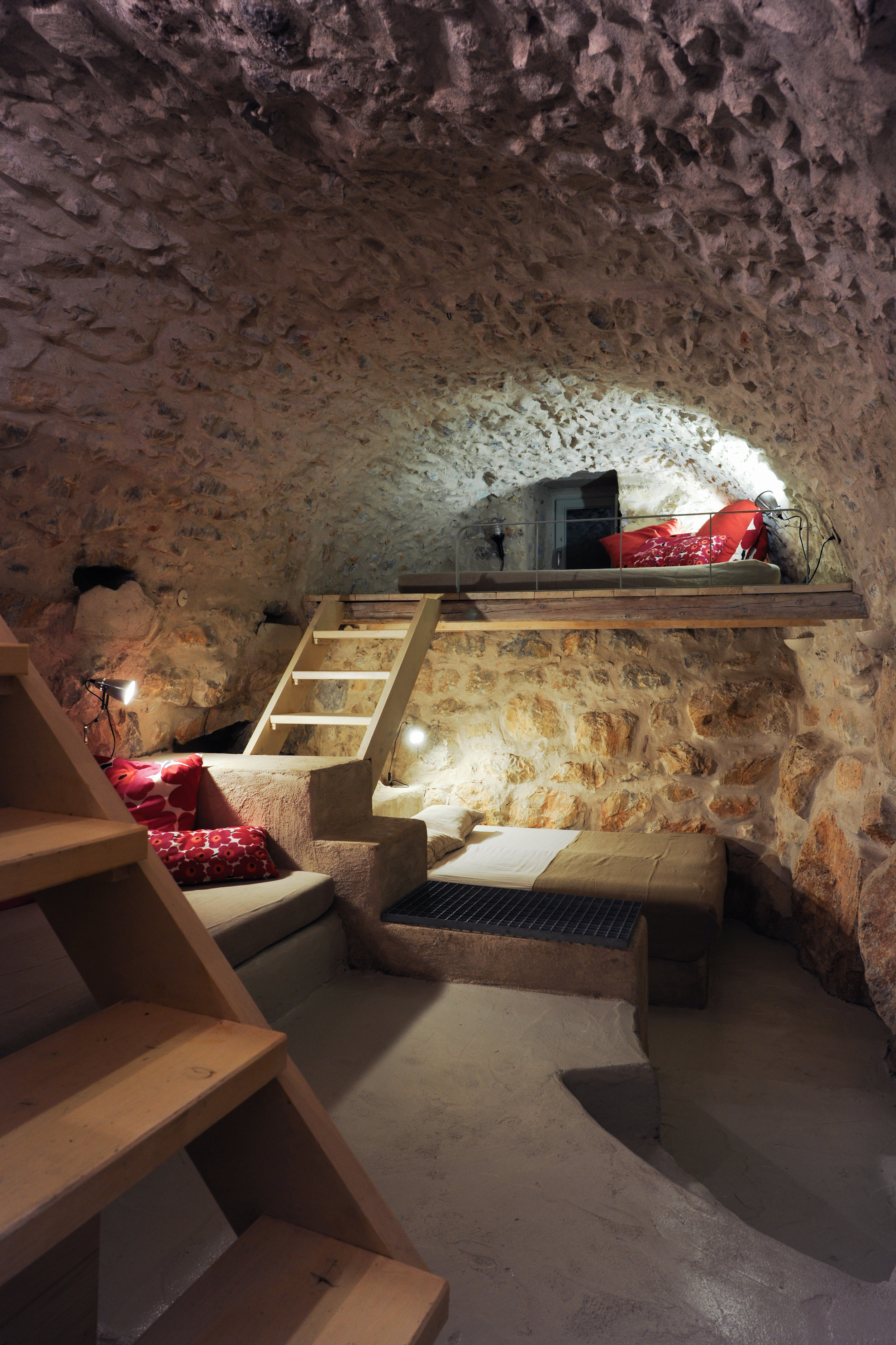 A wooden staircase leads to the middle level, where is the living room and the kitchen.