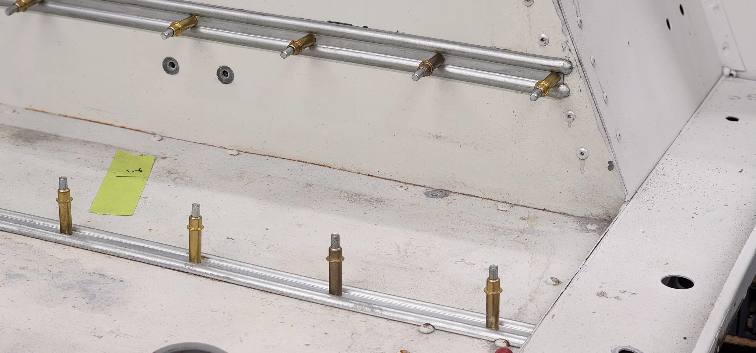 Bare aluminum bodywork with new fasteners during a frame-off restoration