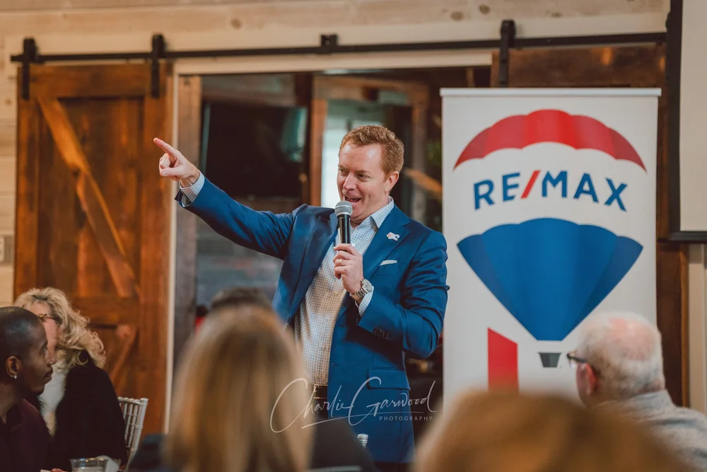 A keynote speaker addressing an audience at a RE/MAX event