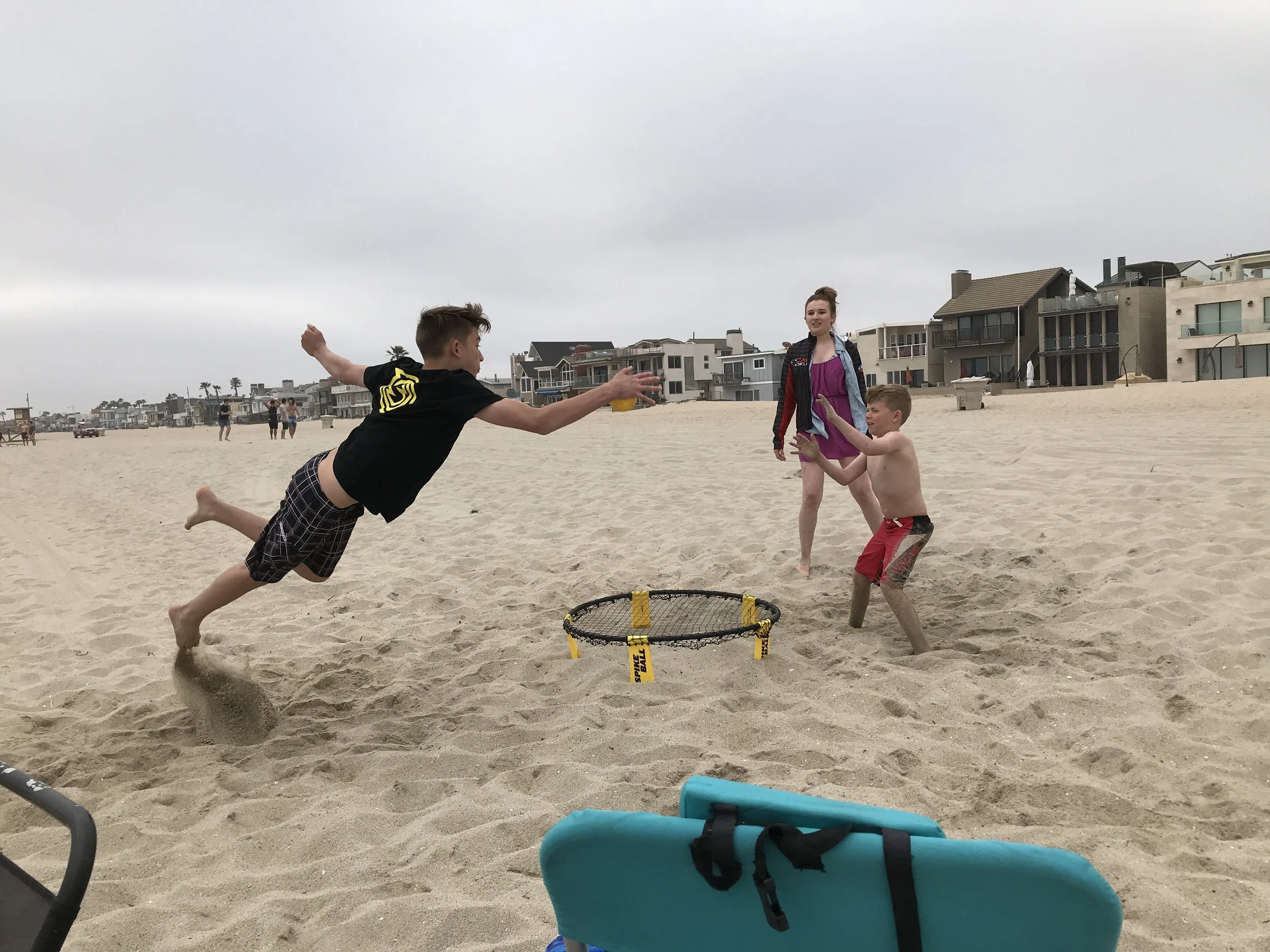 Nate playing on his newly won Spikeball net on the beach with his family.
