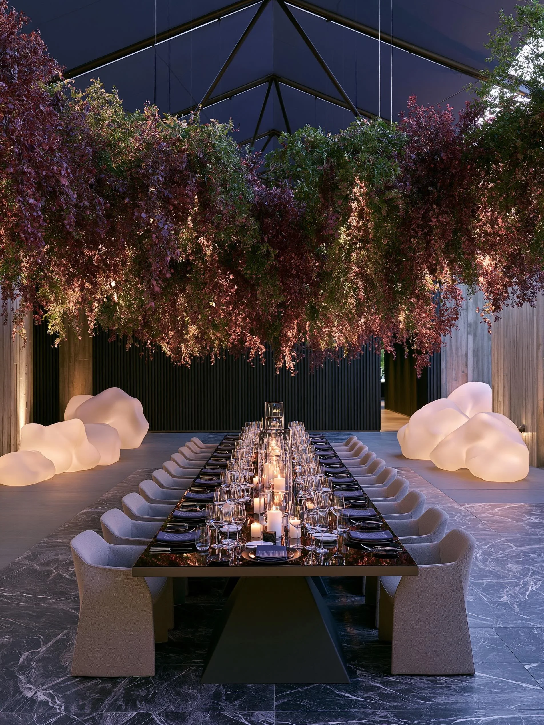 Inspired by overgrown vineyards at twilight, this concept transforms cascading foliage into a floating botanical sculpture hovering above candlelit tables.
A study in atmosphere, restraint, shadow, and modern hospitality.

Concept &amp; Design 
 Noov
