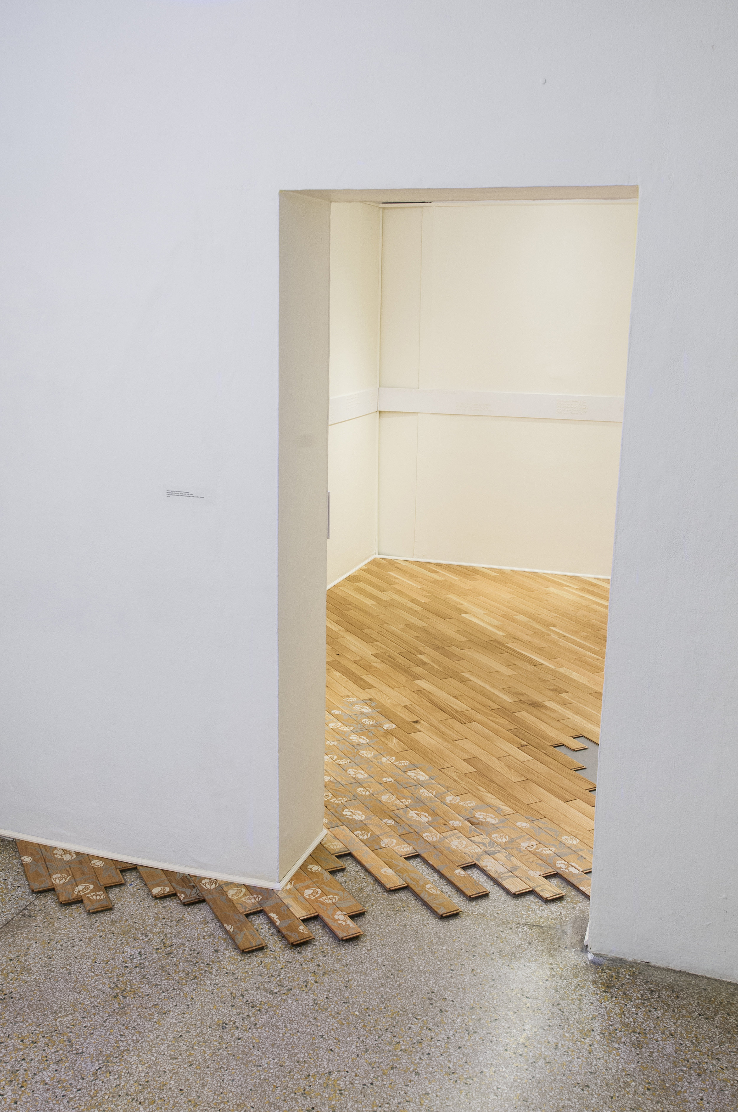 work | space (the laborer revealed) handmade flooring: white oak, milk paint / embroidered worker interview quotes: linen, cotton thread 2013 The act of defining myself as an artist serves as a challenge to my body’s capabilities as a maker. Through this relationship with my work, I have become deeply intimate with the term labor. work | space aims to contextualize my engagement with labor within the universal understanding that human beings possess an inherent need to work. While the interchangeable use of terms such as work and labor is highly disputed, I have found that my role as artist, actions as maker, and identity as worker persuade me to define my work as labor and my labors as work. This subsequent body of work serves as a record of the actions of the laborer. A floor sits; frozen in the process of installation, it awaits the return of the laborer to complete the work. Through the cyclical conversation between the workers’ voices embroidered upon the wall and the work being performed on the floor, the installation serves as the preserved space of the anonymous laborer.