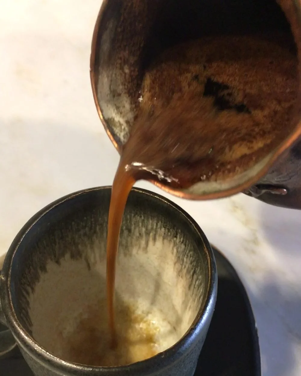 Armenian coffee pouring from a copper jezve into a demitasse cup