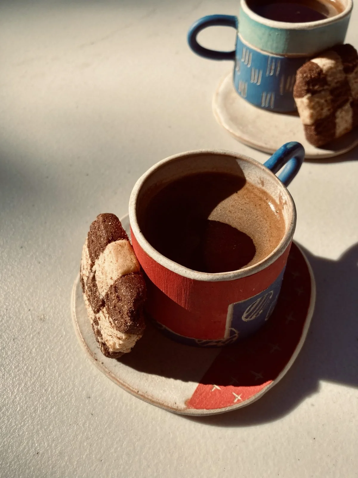 Two cups of Armenian coffee with cookies on handmade saucers