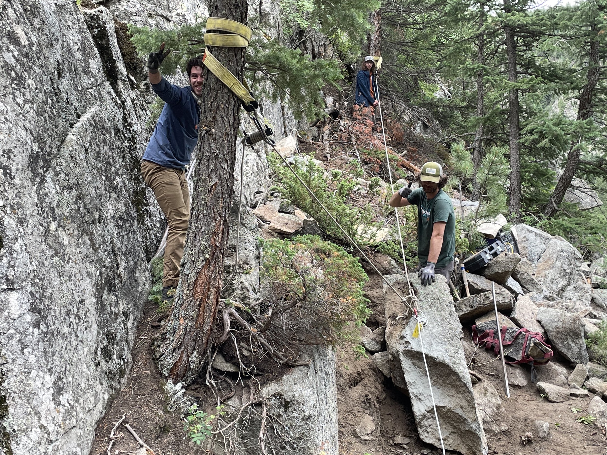 Staff rigging a large rock