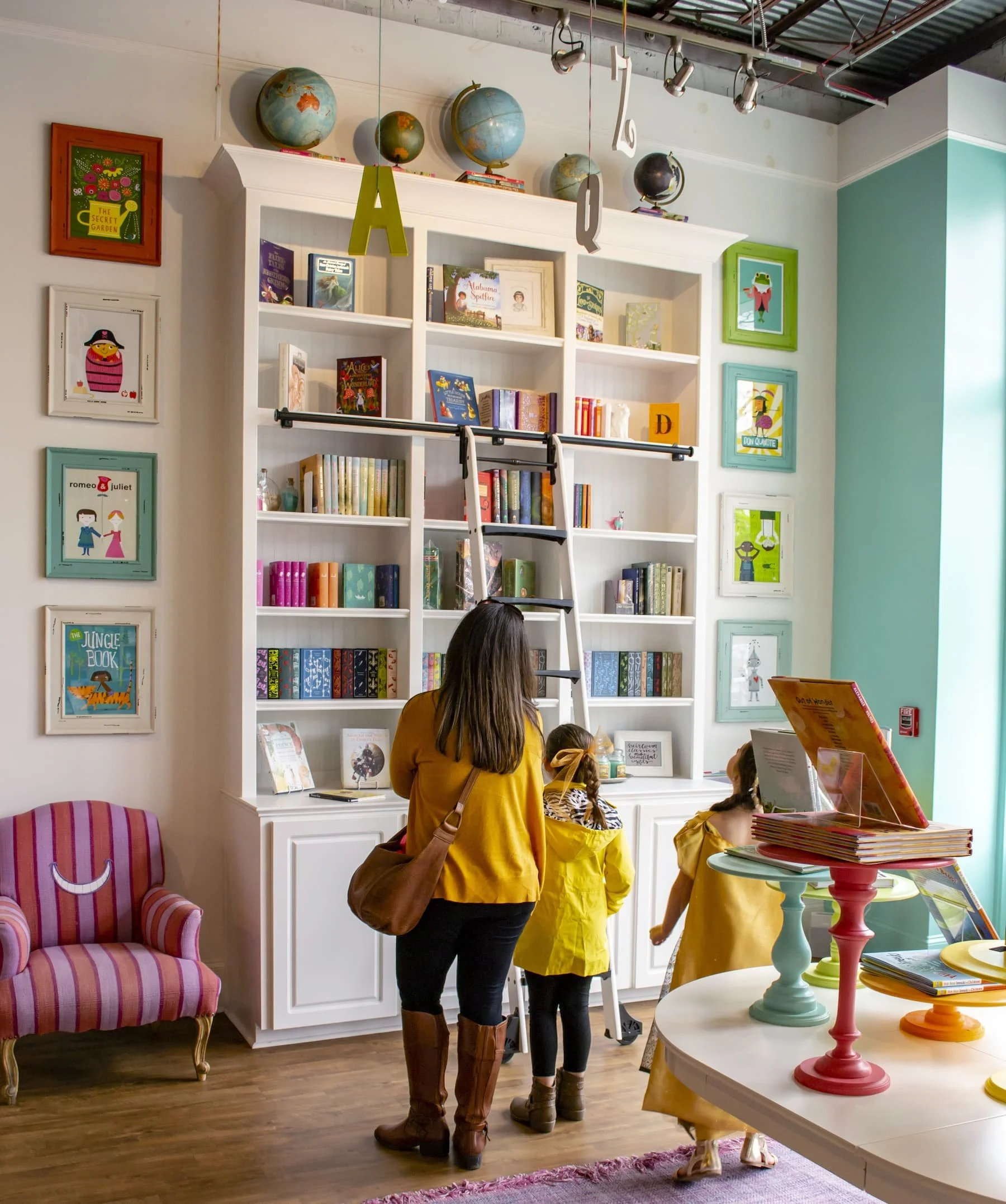 A parent and two children browse books inside The Story Shop children's bookstore in Monroe, Georgia.