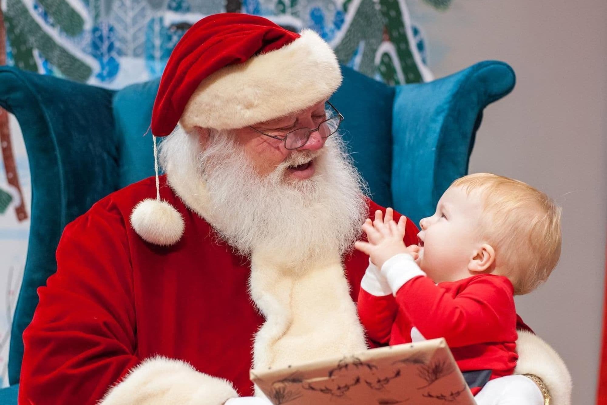 Santa Claus reads a Christmas story to a young child during Cookies with Santa at The Story Shop bookstore in Monroe, Georgia.