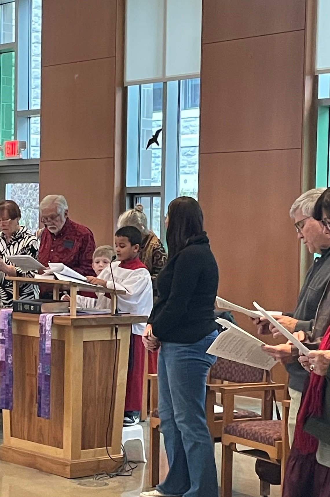 A youth lector reading the scripture lessons at the pulpit during Sunday service at Christ Church Glendale.