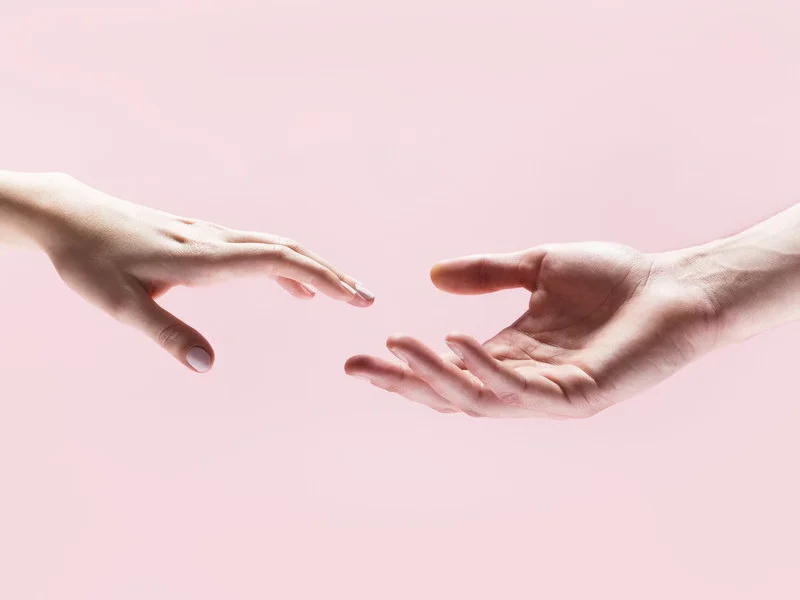 Two hands reaching for each other