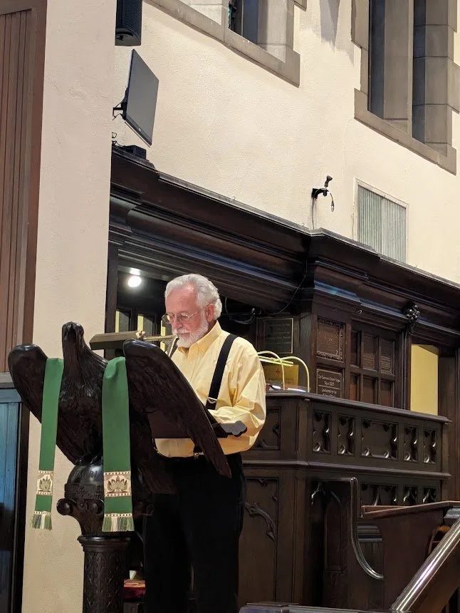 Lector reading scripture from the carved wooden eagle lectern during Sunday service at Christ Church Glendale, Ohio.