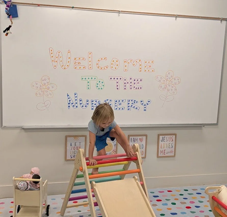 A toddler plays on nursery equipment during 11 am service