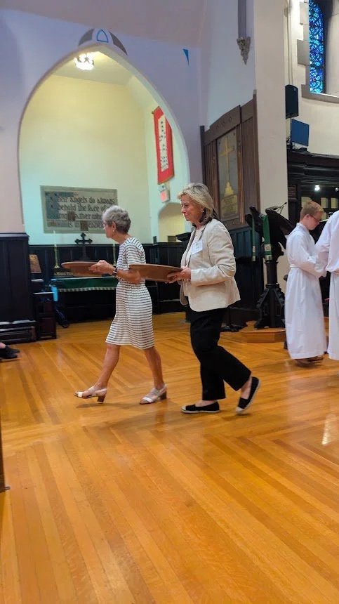 Ushers presenting offering plates at the chancel steps during Sunday worship at Christ Church Glendale, Ohio.