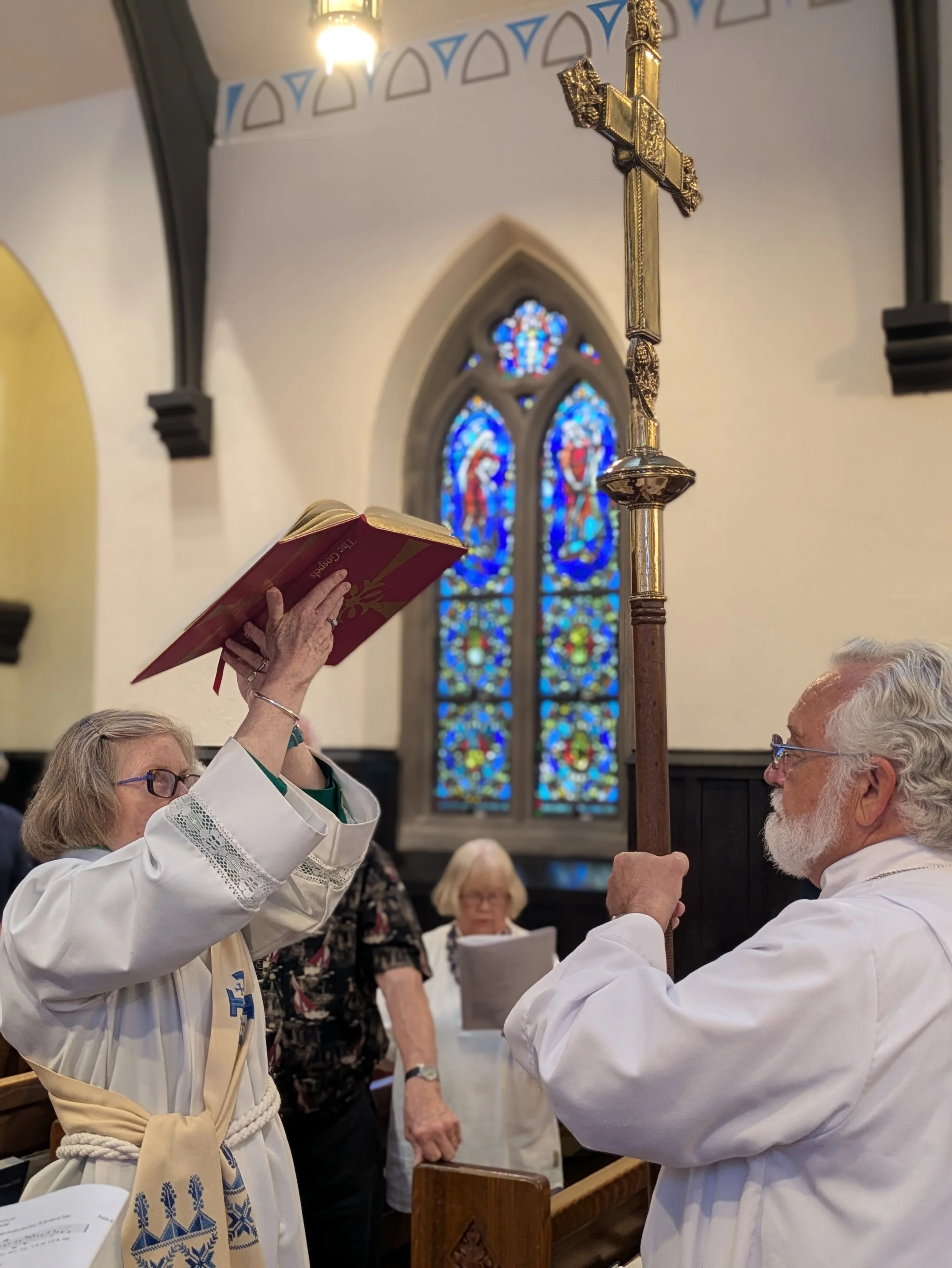 A female decon and an Acolyte preparing saying a blessing as she prepares to read the Gospel